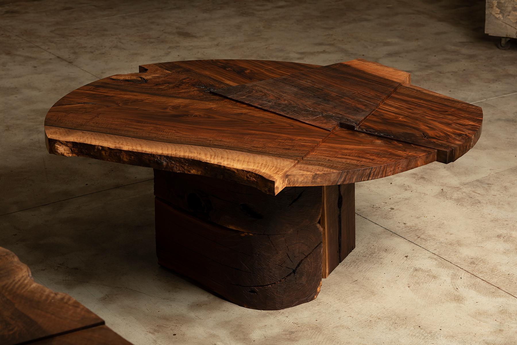 This Strike/Slip dining table 'in the round' by Taylor Donsker features a single California Walnut slab carved into a multi-tiered surface, resting upon a solid Walnut beam base. The result is a sculpted table that offers a functional composition