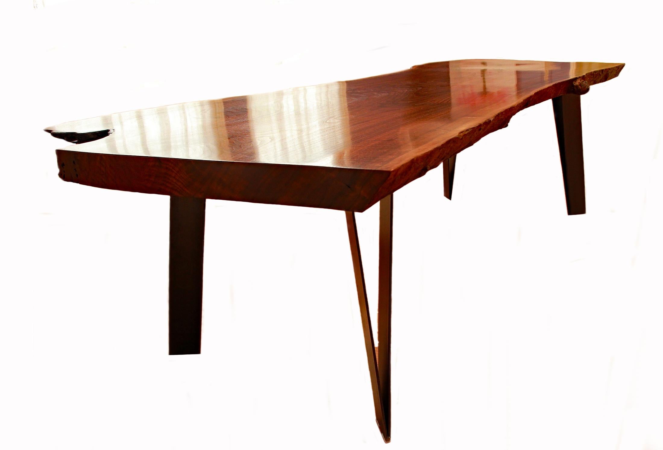 Artist and creator Charles Green is known for his exceptional hand-crafted steel and rare woods custom furniture pieces. This magnificent slab dining table was hand crafted by the artist using a single slab of Claro Walnut, a highly prized wood. The