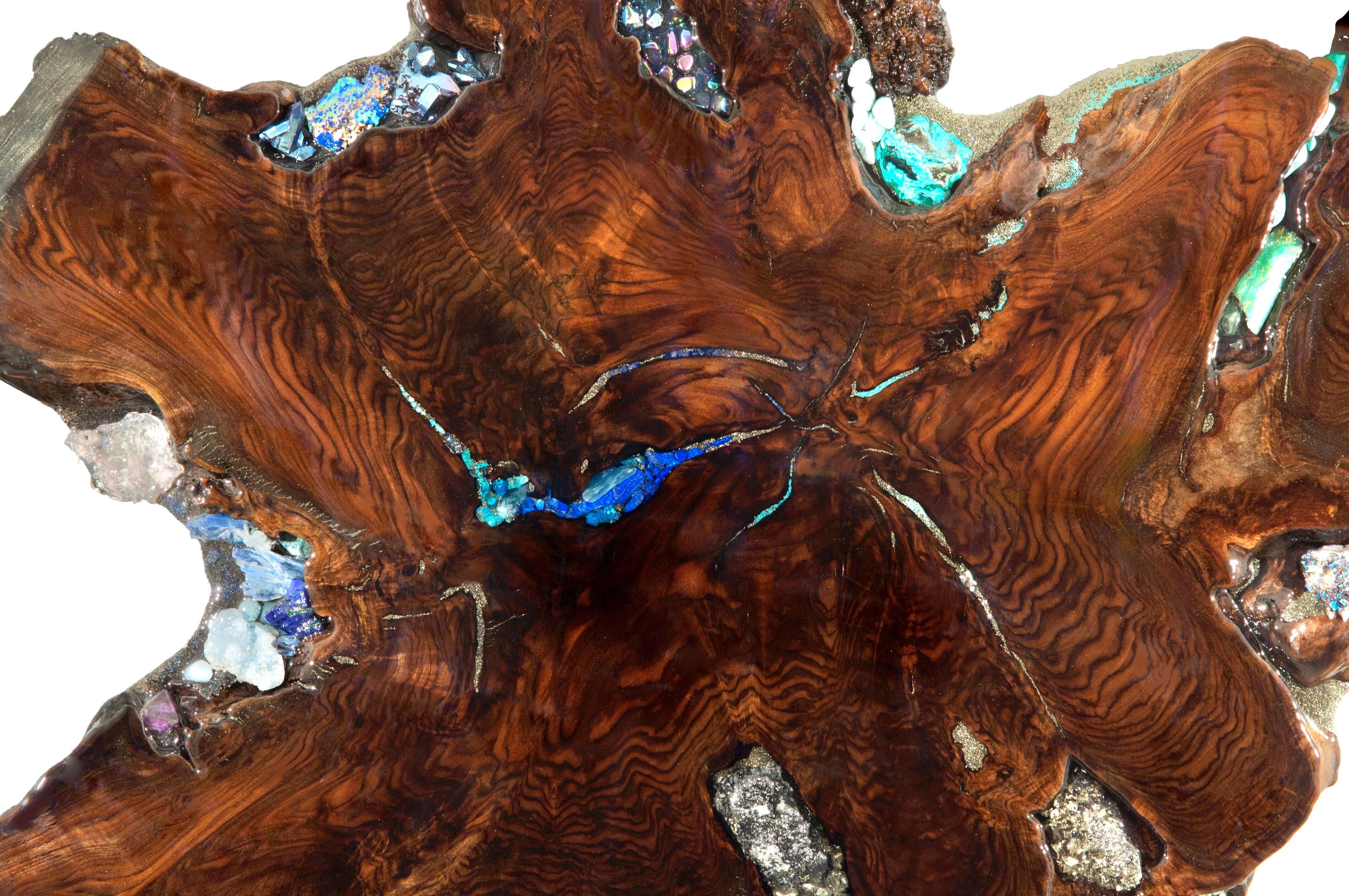 Questo straordinario lavoro fatto a mano con cristalli e pietre preziose è incastonato in uno splendido esemplare di Noce Claro. Si tratta di un pezzo unico che comprende i migliori esemplari di cristalli e gemme: Tanzanite, Lapislazzuli, Kyanite,