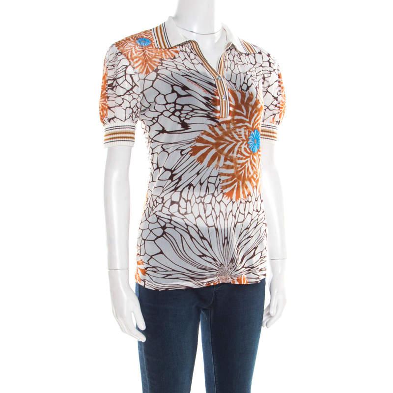 This lovely creation from Class by Roberto Cavalli is made of nylon. It flaunts a floral printed pattern all over it and rib trim detailing along the collar, neckline and the sleeves. The sheer top with its short sleeves is perfect for casual