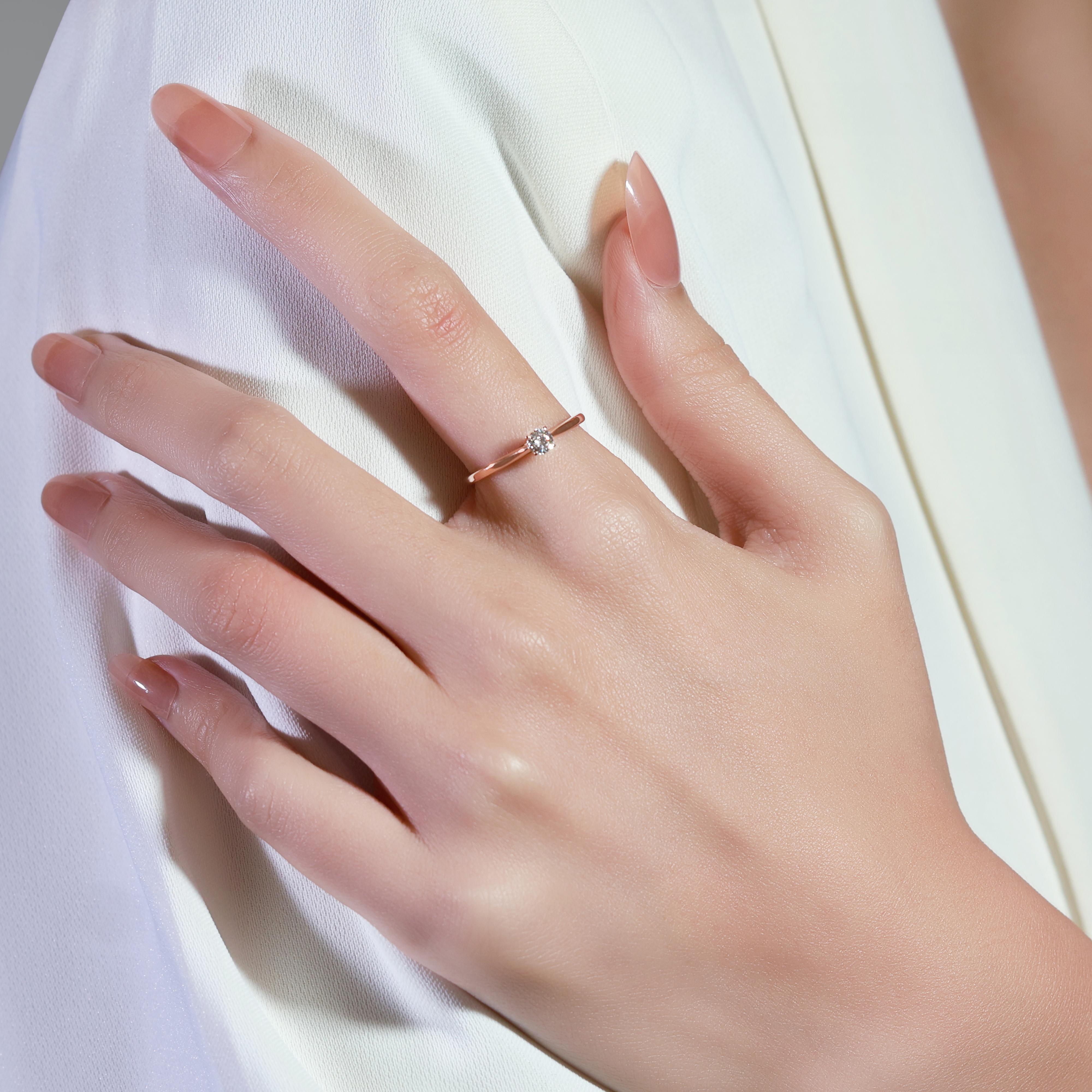 This elegant ring is crafted from 18K rose gold and features a stunning round brilliant diamond with a carat weight of 0.18ct. The diamond showcases a color grade of I and a clarity grade of VS, ensuring exceptional brilliance and quality. With a