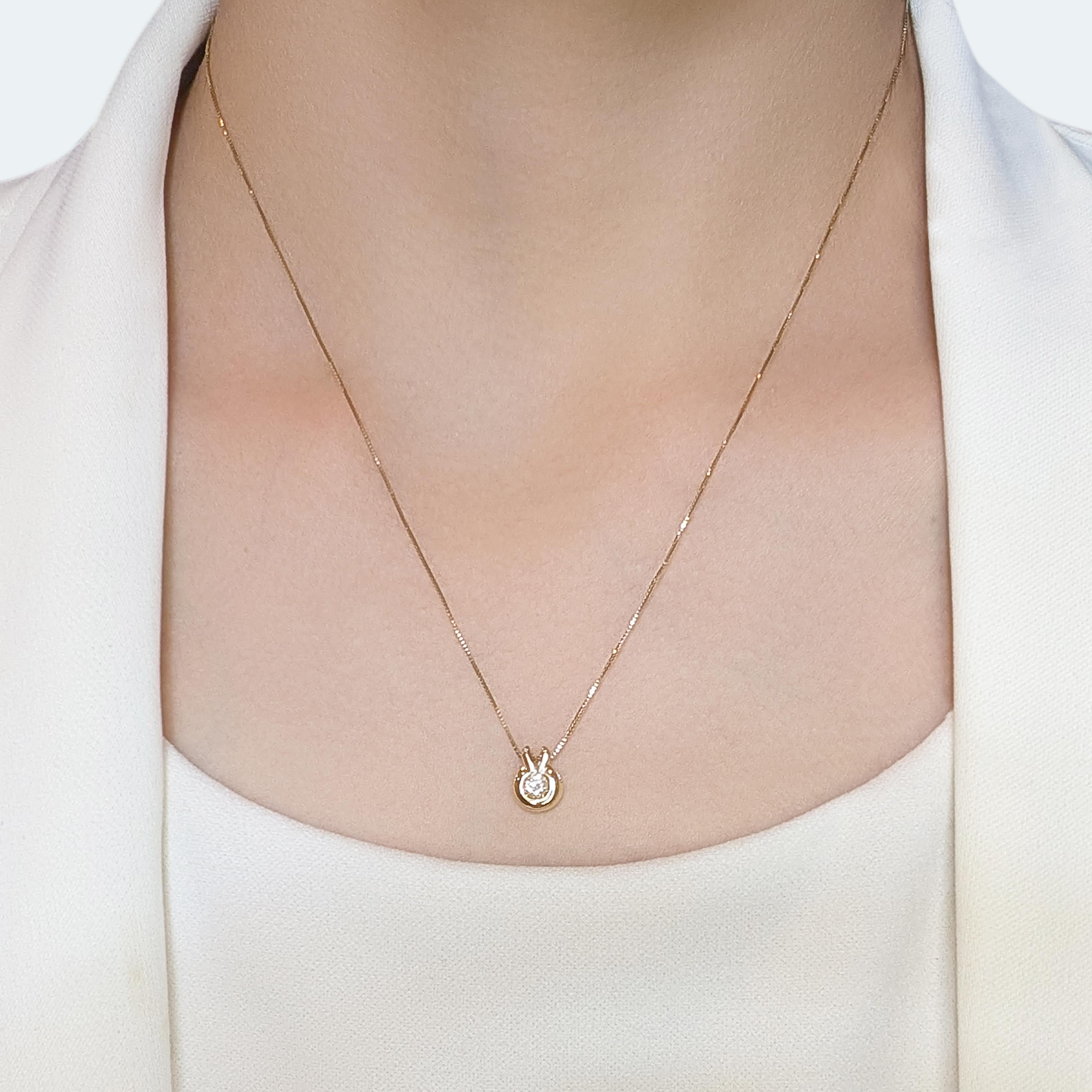 Eleganza con questo squisito ciondolo in oro giallo 18 carati. Con un singolo diamante naturale di 0,2 ct, questa pietra rotonda brillante vanta un colore H e una purezza VS, con uno scintillio che cattura la luce in modo meraviglioso. Con un peso