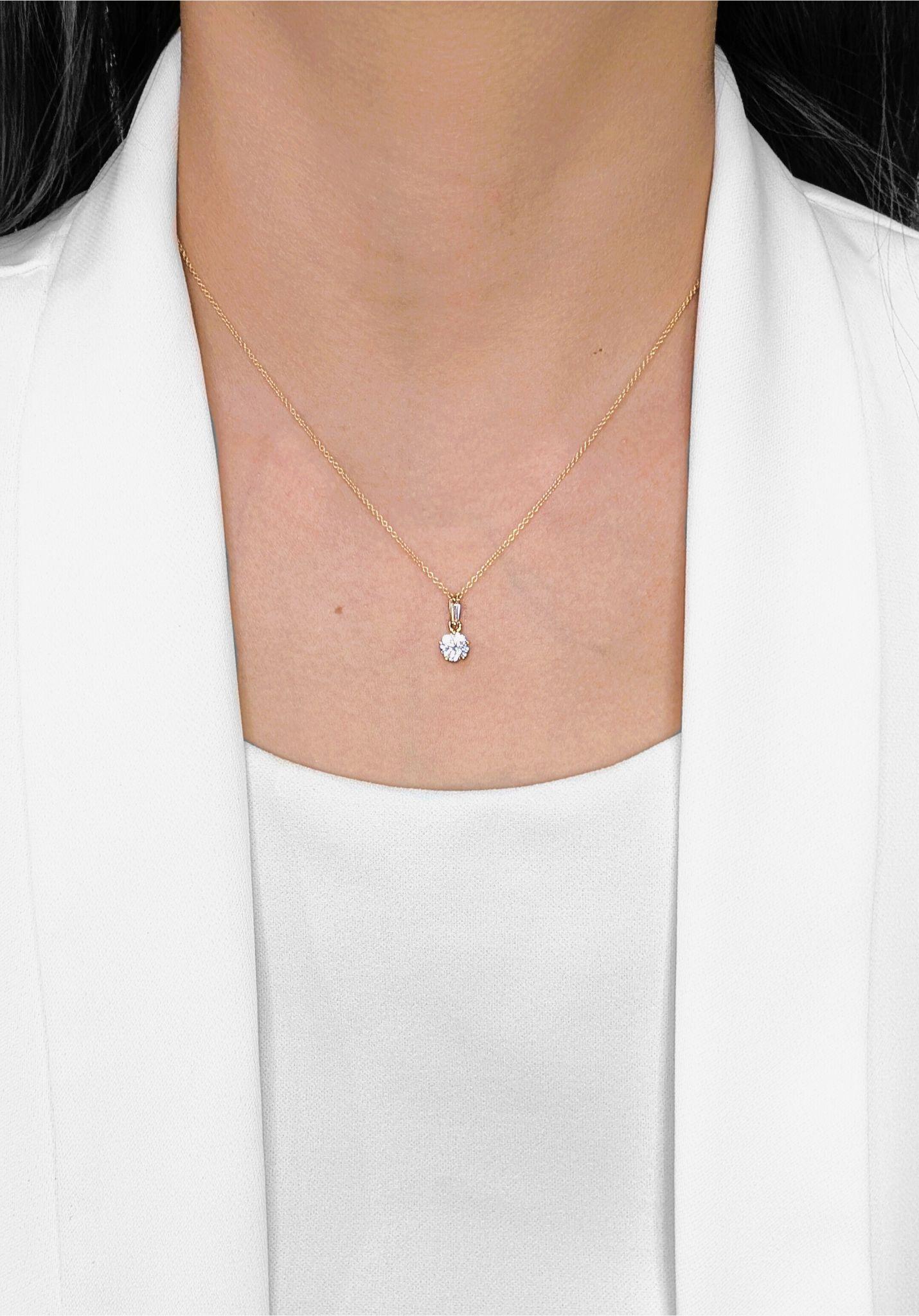 Cet élégant pendentif est réalisé en or jaune 22 carats et met en valeur un éblouissant diamant rond brillant de 0,56 carat d'une pureté exceptionnelle VVS1 et d'une couleur G éclatante. Le diamant est magnifiquement complété par un diamant latéral