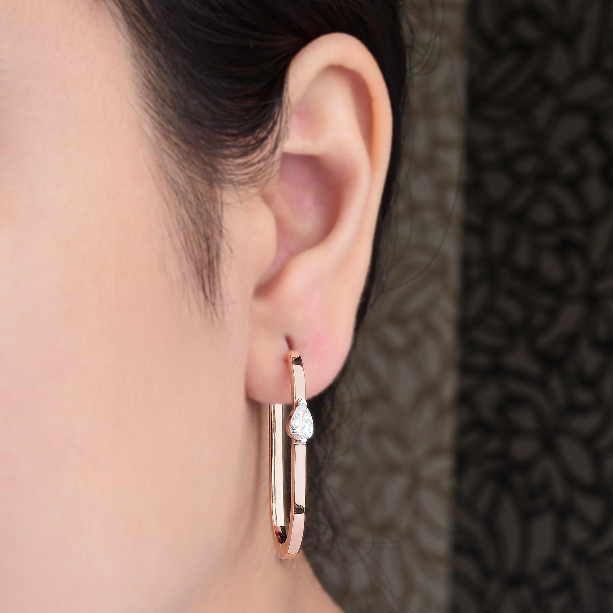 0.82 Carat SI/H Pear Cut Diamond Minimalist Hoop Earrings 18 Karat Rose Gold 
Crafted in a smooth, high-polish 18K gold, these slim hoops embrace a clean, geometric design with a beautiful teardrop-shaped diamond placed at the center for subtle