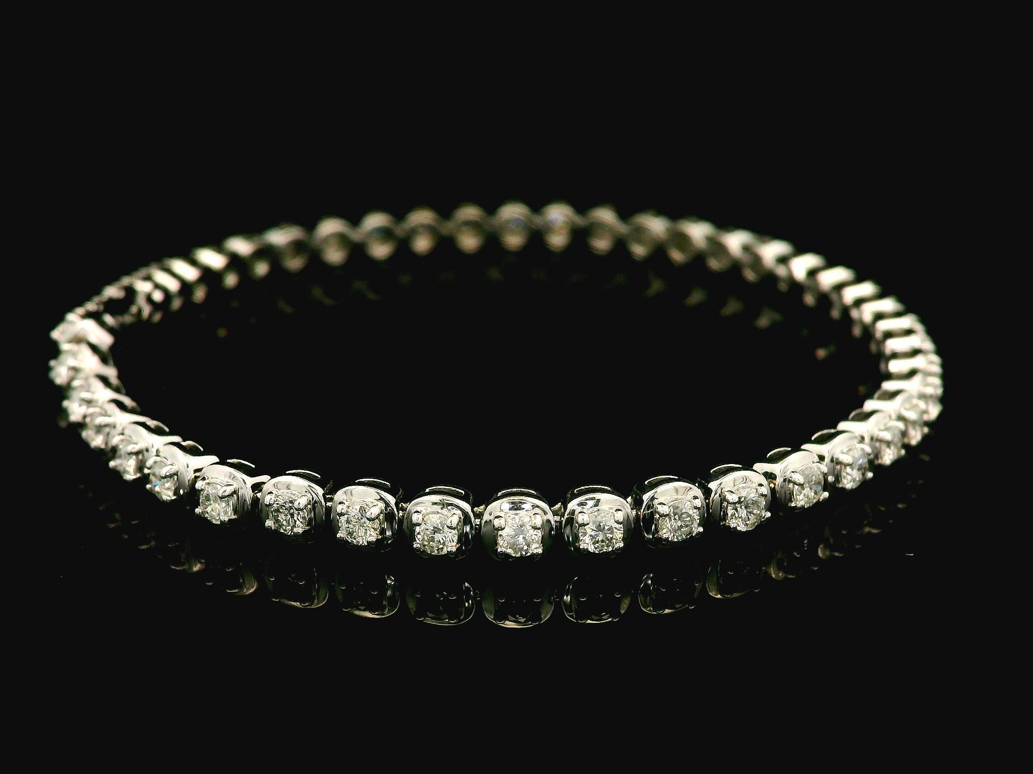 --Stone(s):--
(45) Natural Genuine Diamonds - Round Brilliant Cut - Prong Set - G/H Color - SI1-I1 Clarity
Total Carat Weight: 1.8 (approx.)

Material: Solid 14K White Gold
Weight: 8.83 Grams
Type: Tennis Line Link
Chain Length: Measures 6.75 Inches