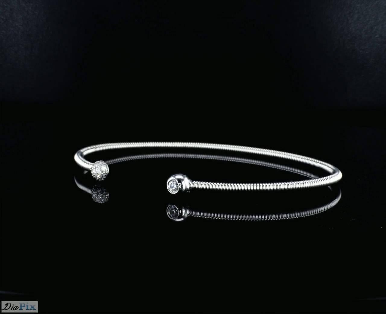 14K White Gold bangle bracelet with diamonds on the sides. This classic spring bracelet is flexible.  
Side diamonds- 15 diamonds round brilliant cut ,  0.13 Carat total diamond weight,  G-I / SI- VS 
Bracelet is Oval and approximately 6 centimeter