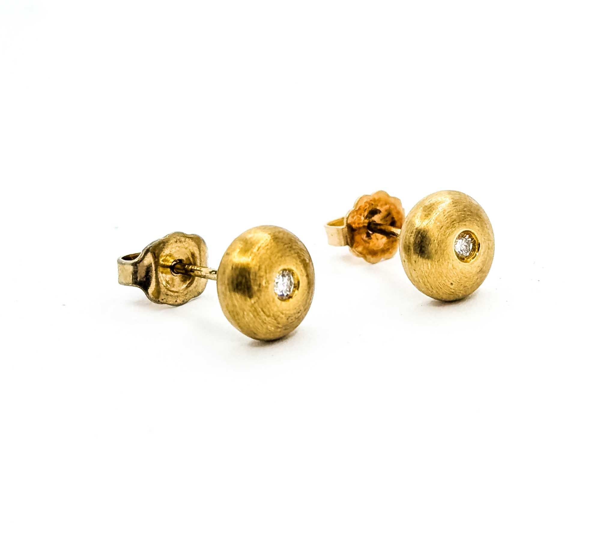 Estos pendientes atemporales están fabricados en oro amarillo de 14 quilates y presentan un diseño sutil pero llamativo. Cada pendiente mide 8 mm de diámetro y está engastado con un diamante redondo de aproximadamente 0,04 quilates de peso