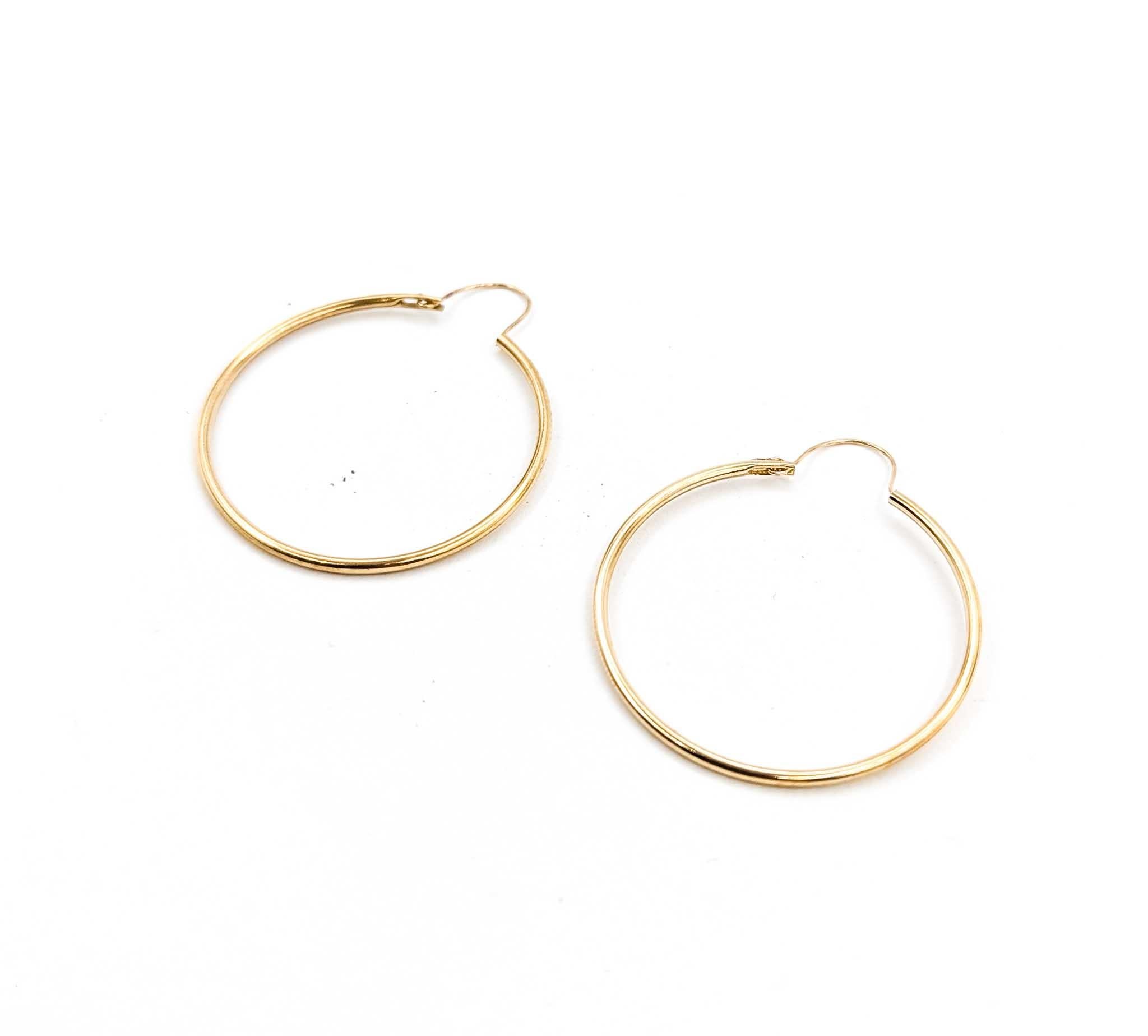 Atemporales y versátiles, estos pendientes de aro clásicos están elaborados en oro amarillo de 14k. Miden 29 mm de diámetro y 1,25 mm de ancho, y ofrecen un diseño ligero pero duradero, con un peso de 1,5 gramos. Su forma sencilla y elegante los