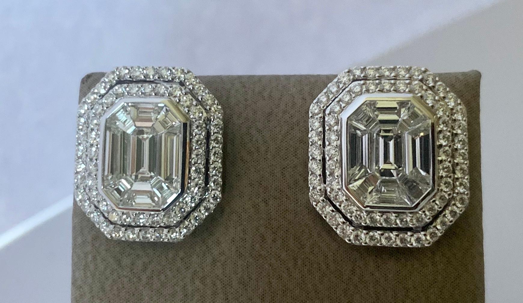  A pair of modern emerald cut illusion diamond cluster earrings crafted in 18 K white gold. The centre  is composed of  a mosaic of 18 Diamond baguettes with a total weight of 1.35 ct, G color, vs clarity to give the illusion of being on single