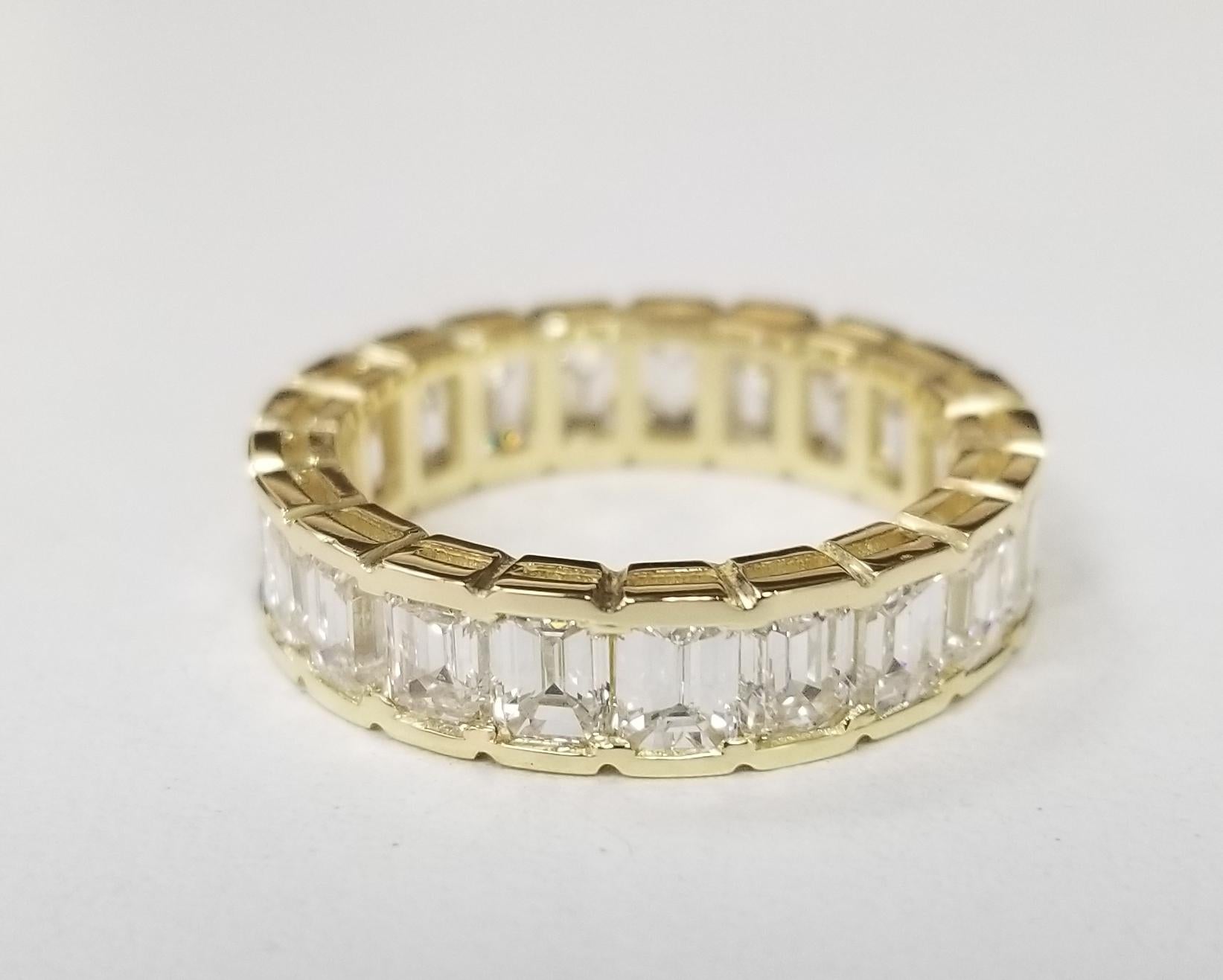 A breathtakingly beautiful diamond wedding band featuring 21 emerald cut diamonds set in 18k yellow gold weighing 5.10carats. These spectacular diamonds are G in color, VS1-2  clarity. This seamless channel set eternity band is expertly crafted