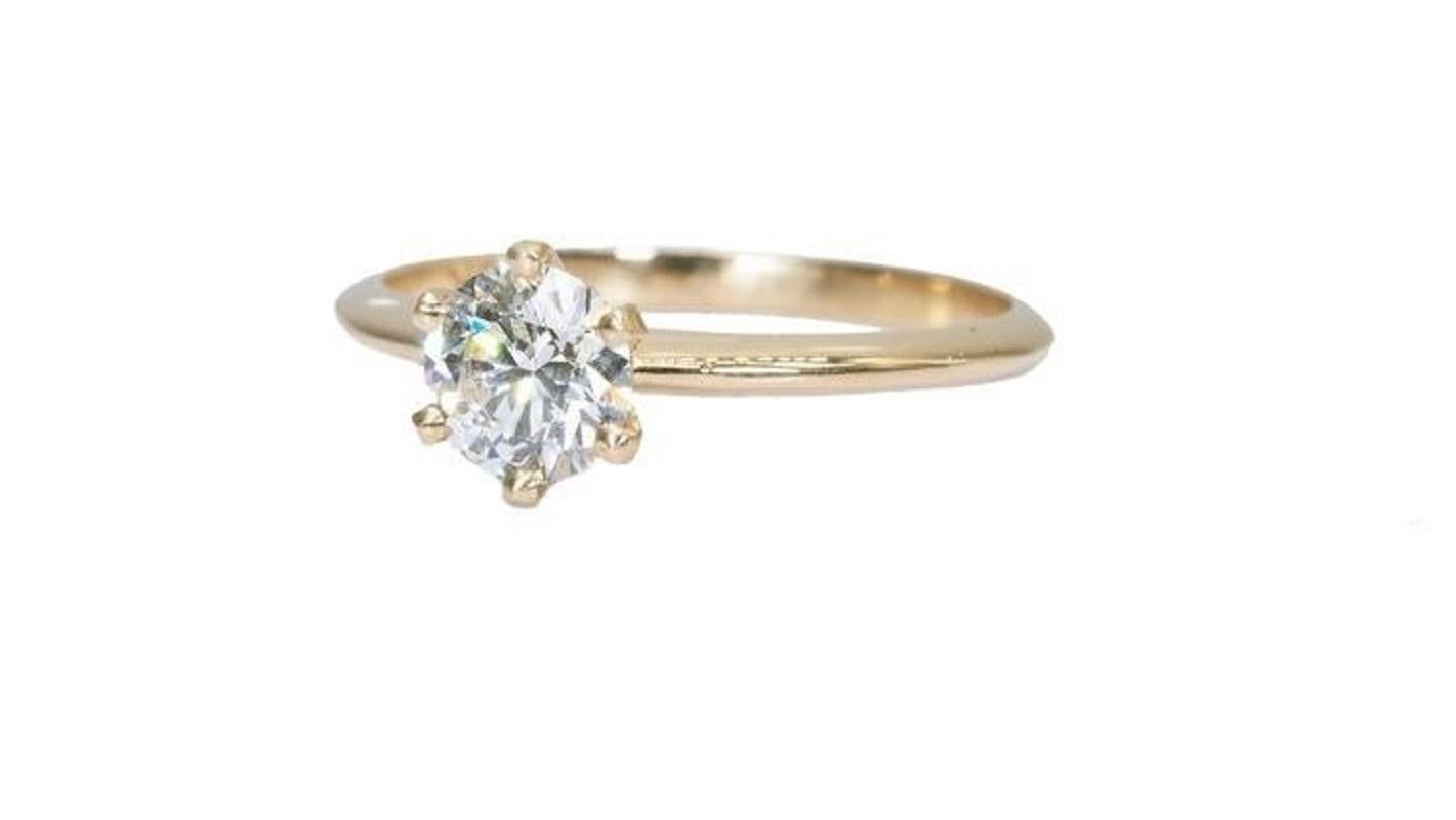 A stunning classic solitaire tiffany ring with a dazzling 1.18 carat round brilliant natural diamond in J VVS2 with ideal cut. The jewelry is made of 18K yellow gold with a high quality polish. The main stone is engraved with a laser inscription and