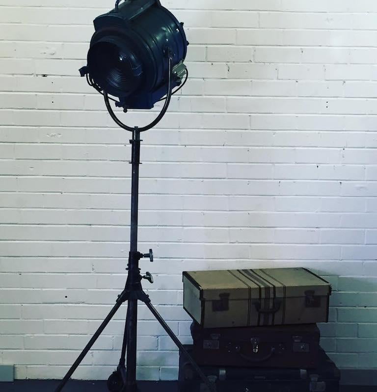 Classic film studio light made by J G. McAlister, Inc. of Hollywood, CA during the 1930s. Rewired with standard Edison bulbs to be used as a standing lamp. 

It is a spot, originally designed for use in film and television. Light features the