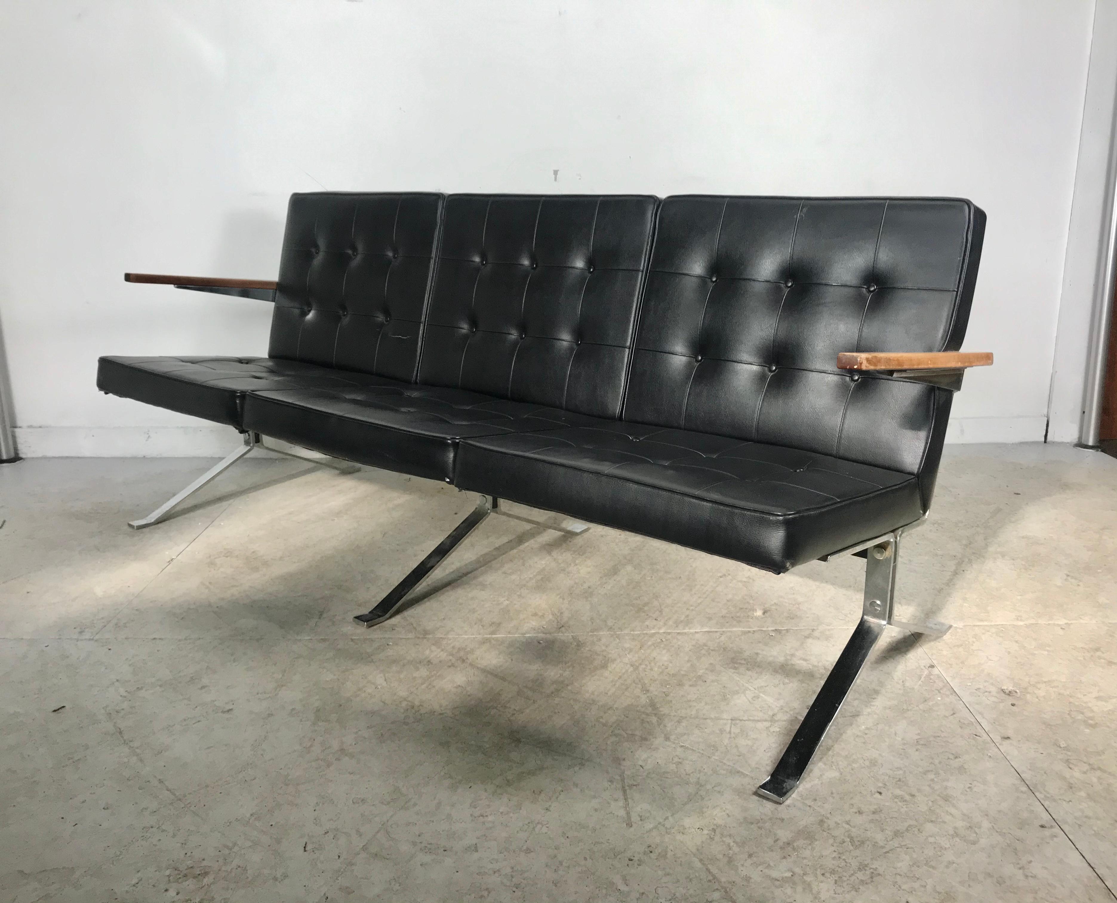 Classic 1960s modernist, Space Age black and chrome bench Sette. Reminiscent of the Classic designs of Arne Norell, Nelson Knoll. Black tufted Naugahyde seat and back, heavy chromed steel base. Wooden arms. Minor retains original upholstery, minor