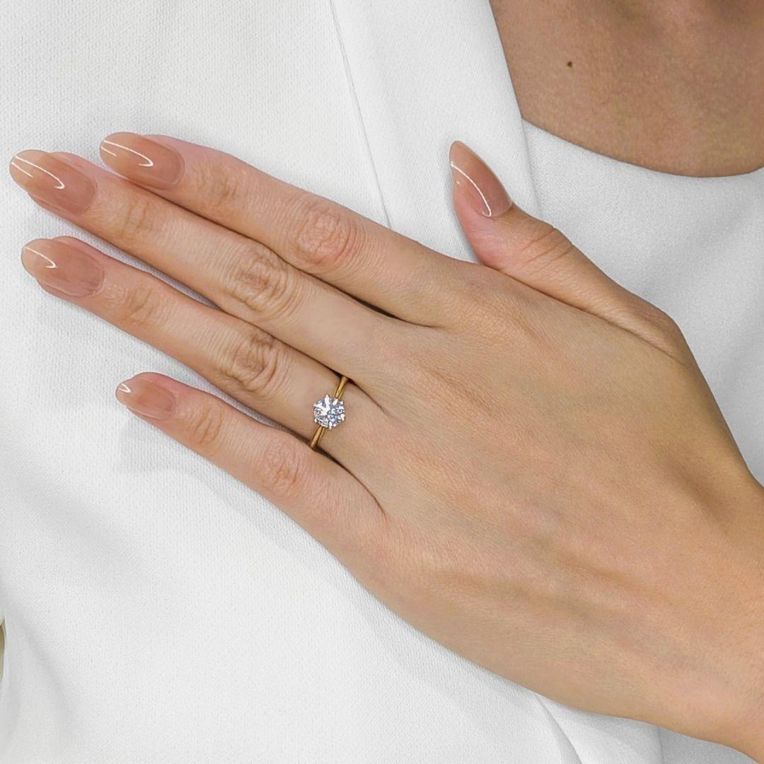 A symbol of elegance and everlasting beauty, this stunning 18K yellow gold solitaire ring showcases a 1.00-carat round brilliant natural diamond, radiating brilliance with its G-color and SI2 clarity. The classic setting allows the diamond to take