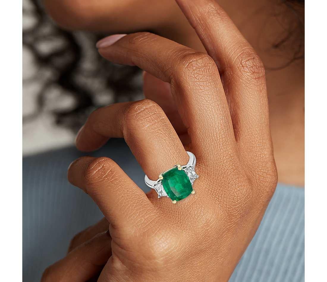The classic, three stone is 4.79 ct central emerald cushion cut GIA certified with the measurements of 10.12 x 10.07 x 7.91 mm given prominence by trapezoid side diamonds, each weights 0.25 carats ( 0.50 ct total ) which makes the total of 5.29 ct