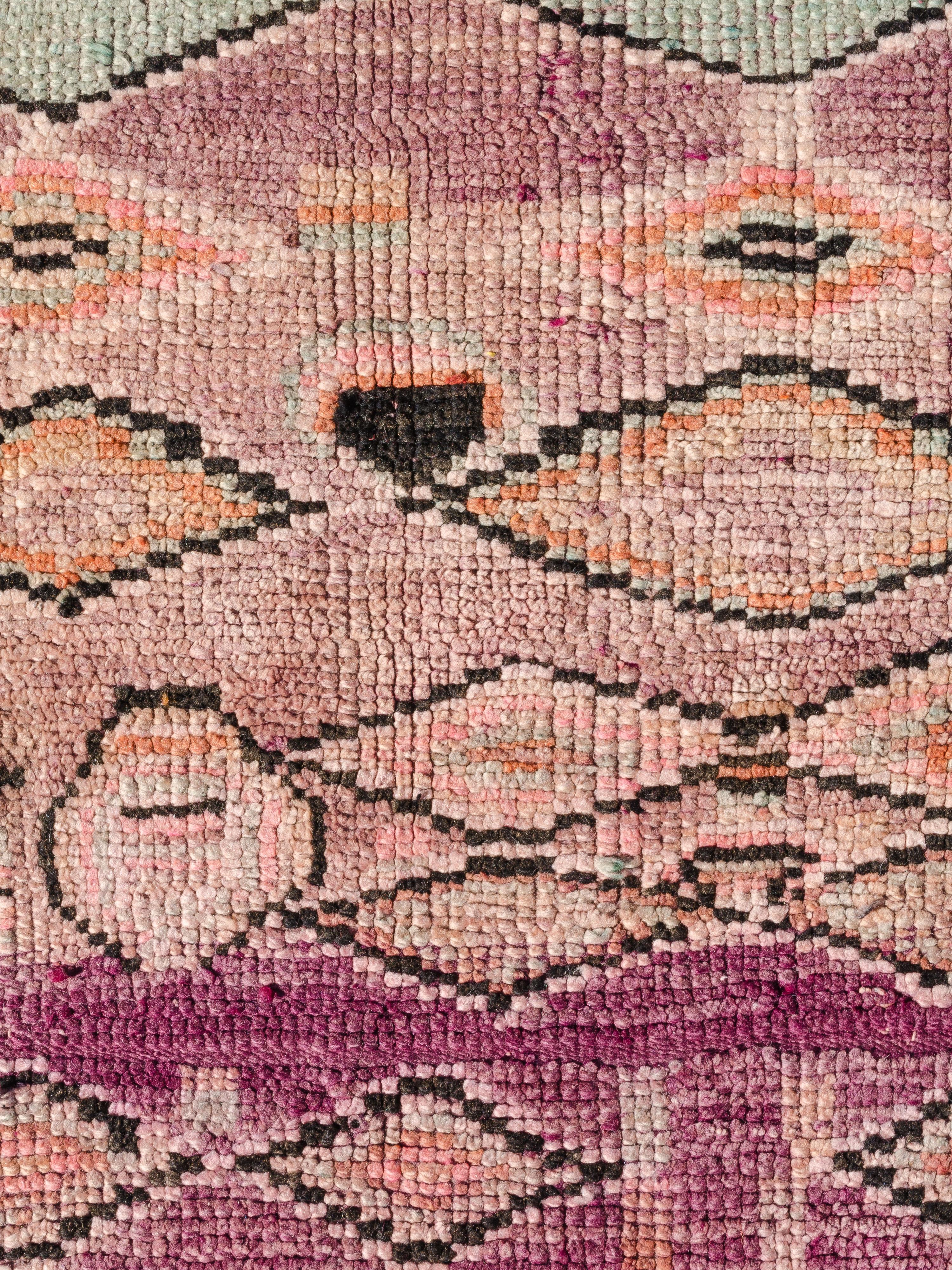 This classic Boujad features vertical and horizontal chains of lozenges floating over an abrashed magenta field. Male bar and rod motifs are randomly placed throughout the composition, adding spontaneity to an otherwise rather structured pattern.
