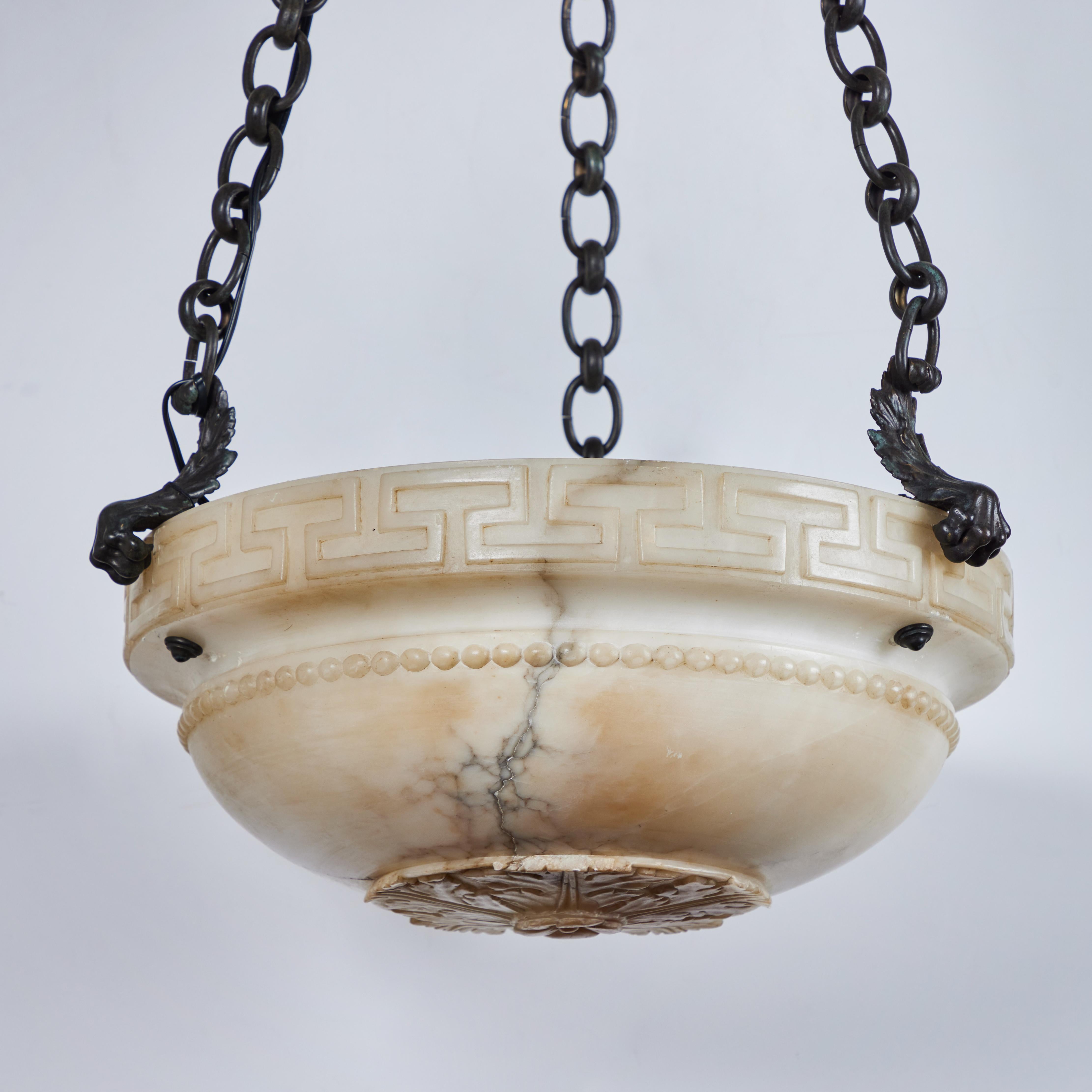 Beautifully hand-carved  alabaster bowl chandelier with the classic Greek Key motif. Held by bronze claws, chains and acanthus leaf canopy.