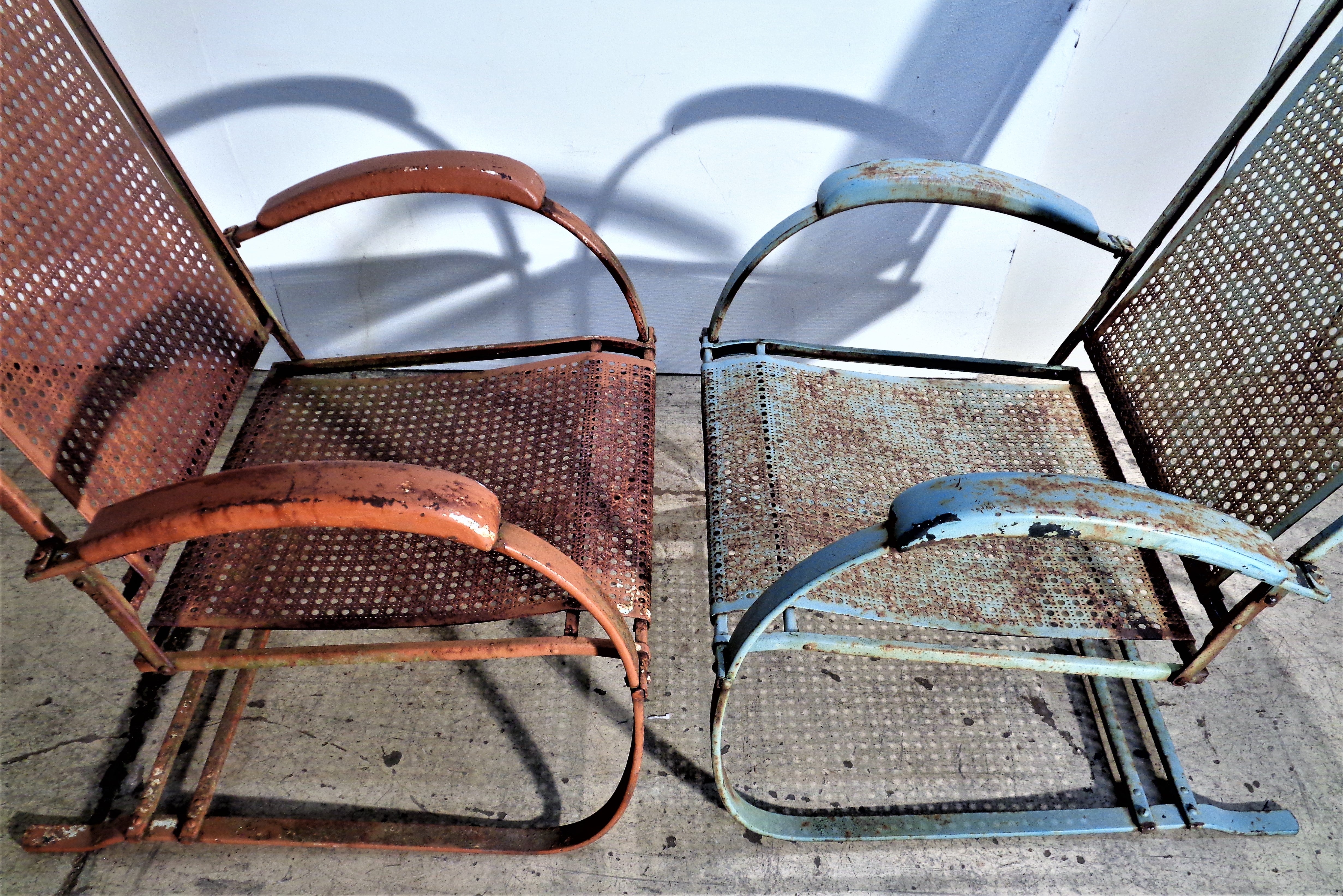 A large scale pair of spring steel metal mesh high back cantilever bounce armchairs in beautifully aged original worn pale blue and salmon painted surface. Manufactured by Howell Company, circa 1930's. A find model with classic old school style and