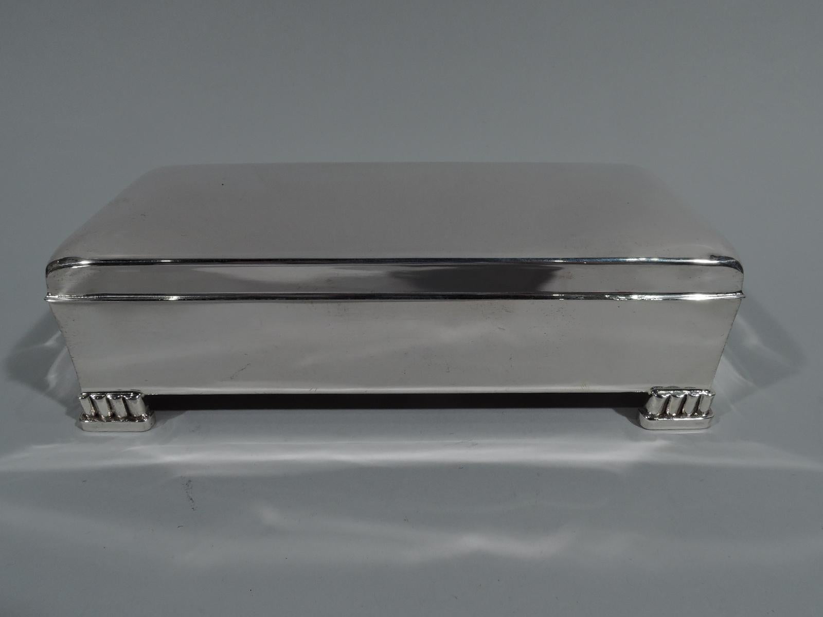 Classic Mid-Century Modern sterling silver box. Made by Poole in Taunton, Mass. Rectangular with straight sides. Cover hinged with curved top, straight sides, and flat overhanging rim. Corner supports in form of bracket colonnade on base. Box