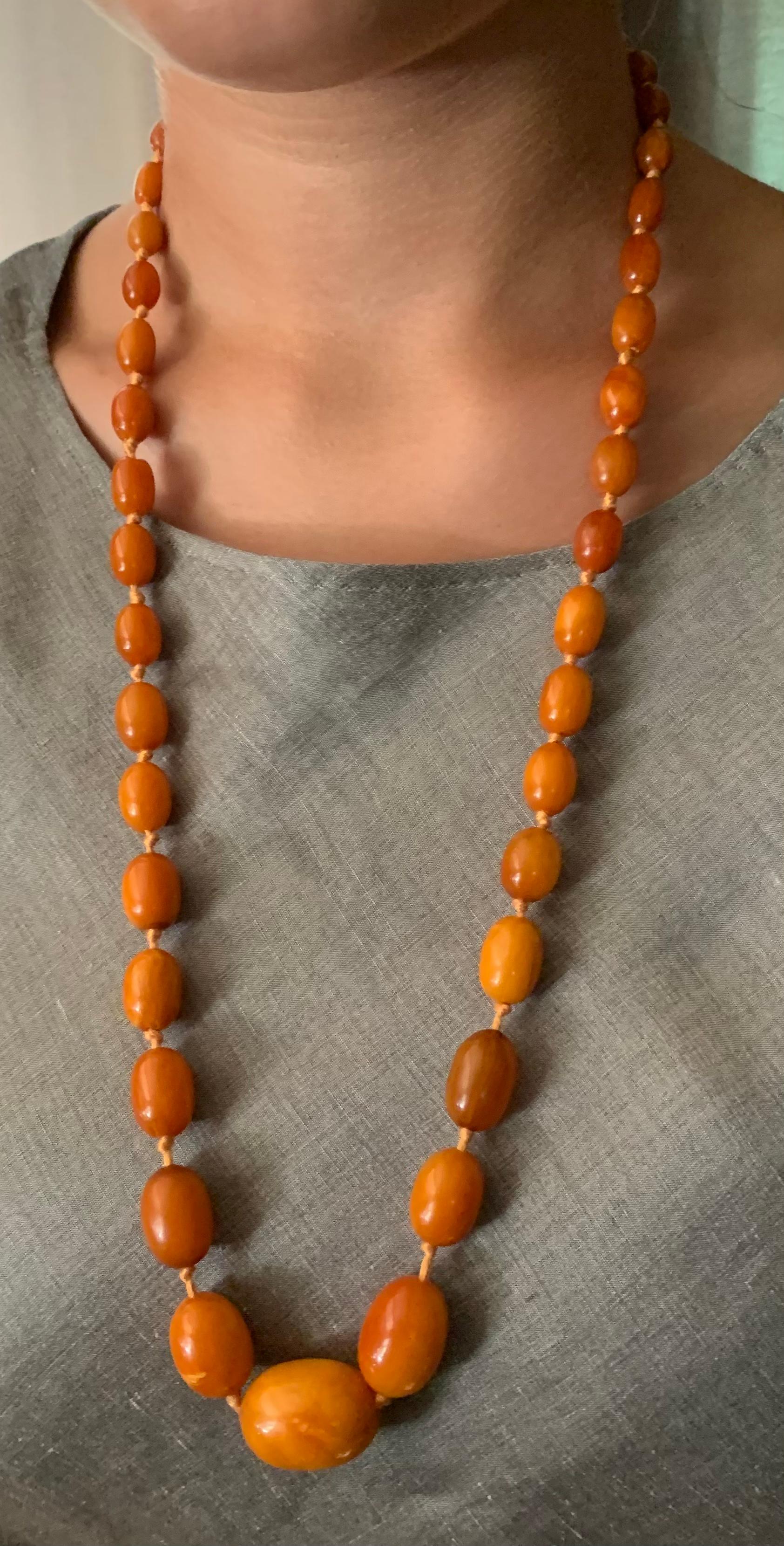 Comprised of forty two graduated oval natural amber beads ranging in size from 27mm to 7mm with nice patina, hand tied with later 14K gold clasp.
Amber is fossilized tree resin which has been prized as a gemstone since antiquity. It has been used as