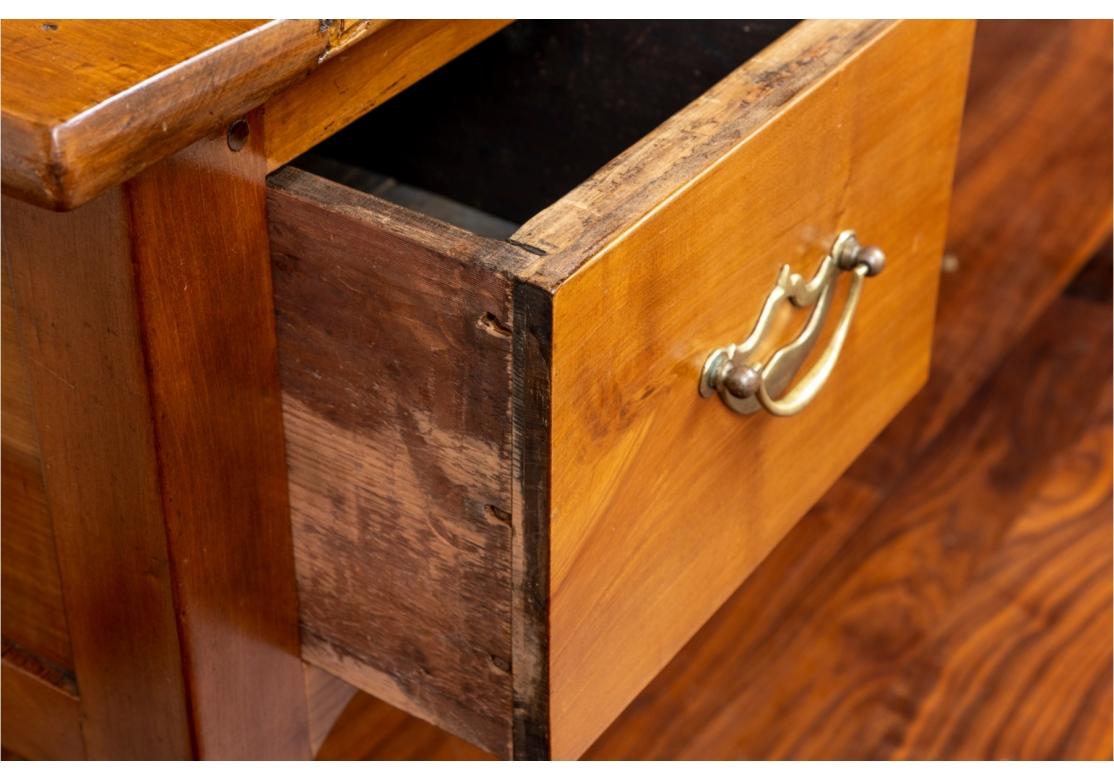 A Classic Antique Provincial French writing table with breadboard top. Plank top two drawer desk featuring scalloped knee hole and apron with two drawers with brass pulls on simple cabriole legs.
57