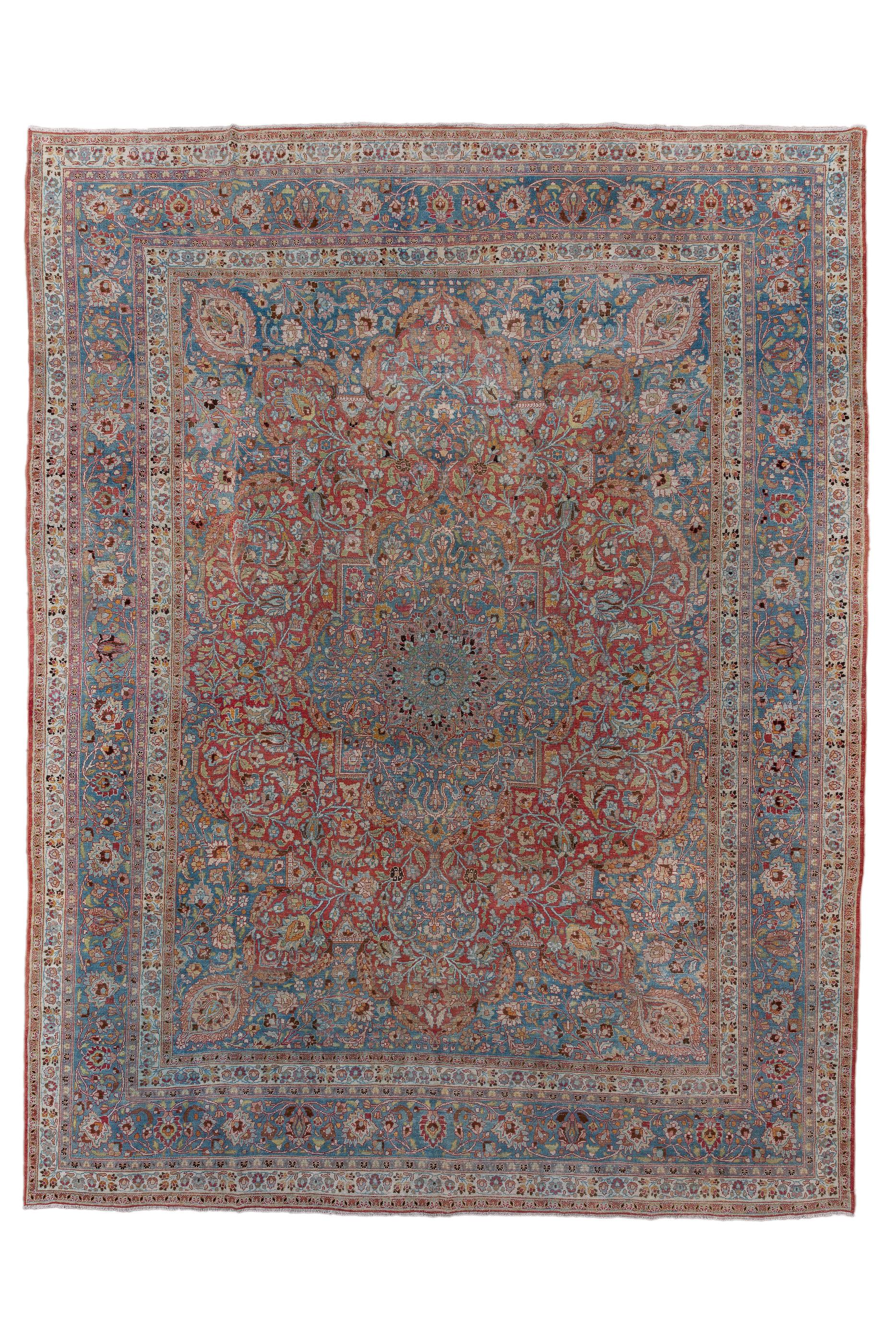 This finely woven city carpet shows the classic Kashan red field, centred by  a blue-green millefleurs medallion with escutcheon pendants, set within en suite blue-green extended corners, all sections with varying millefleurs designs. Oval palmettes