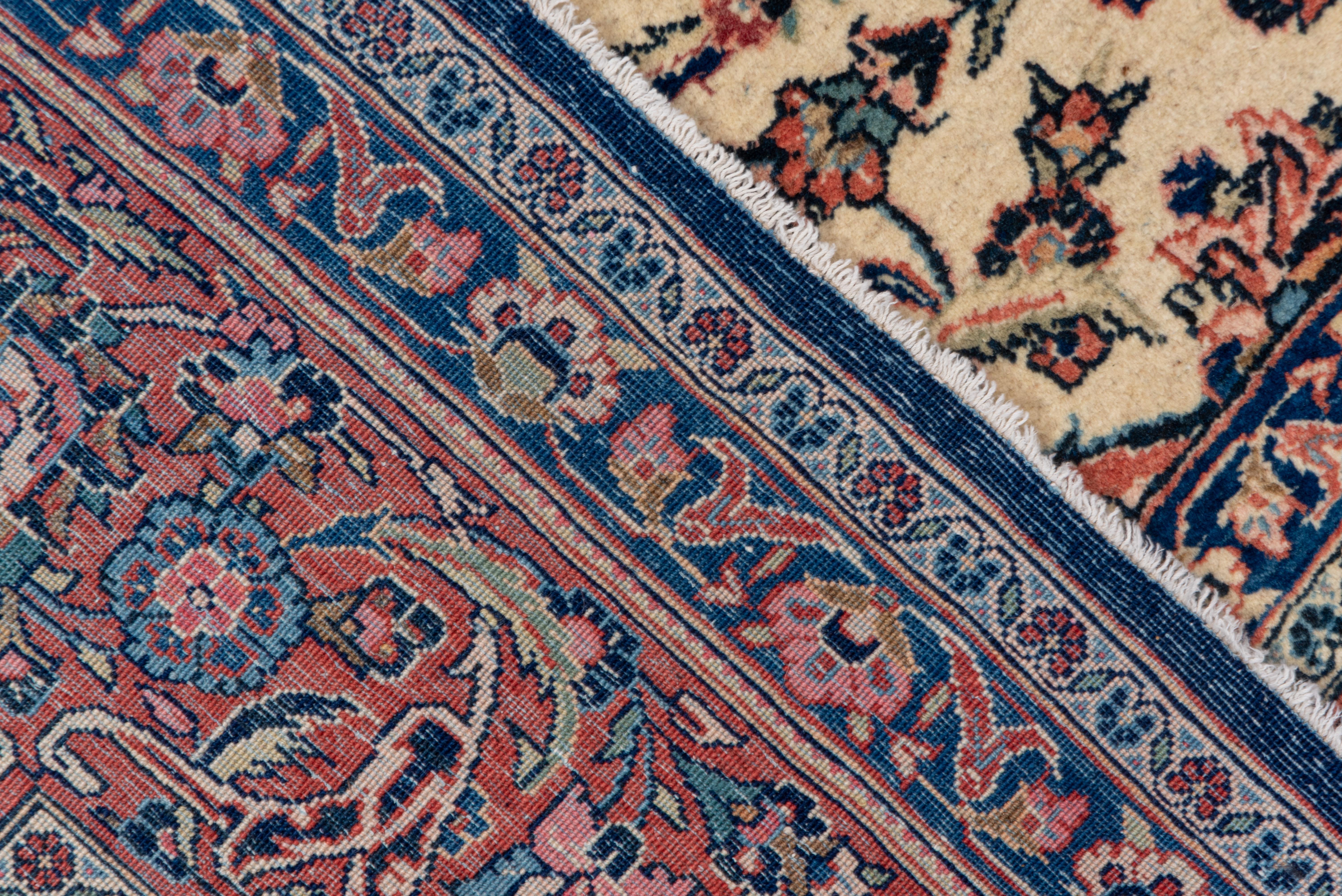 This is a Classic medium-fine, central Persian city carpet with a round navy medallion with pendant chains, on a cream sand field with palmettes,multi-level vinery and curved leaves. Small rose corners. Rose coral border with palmettes. Unusual