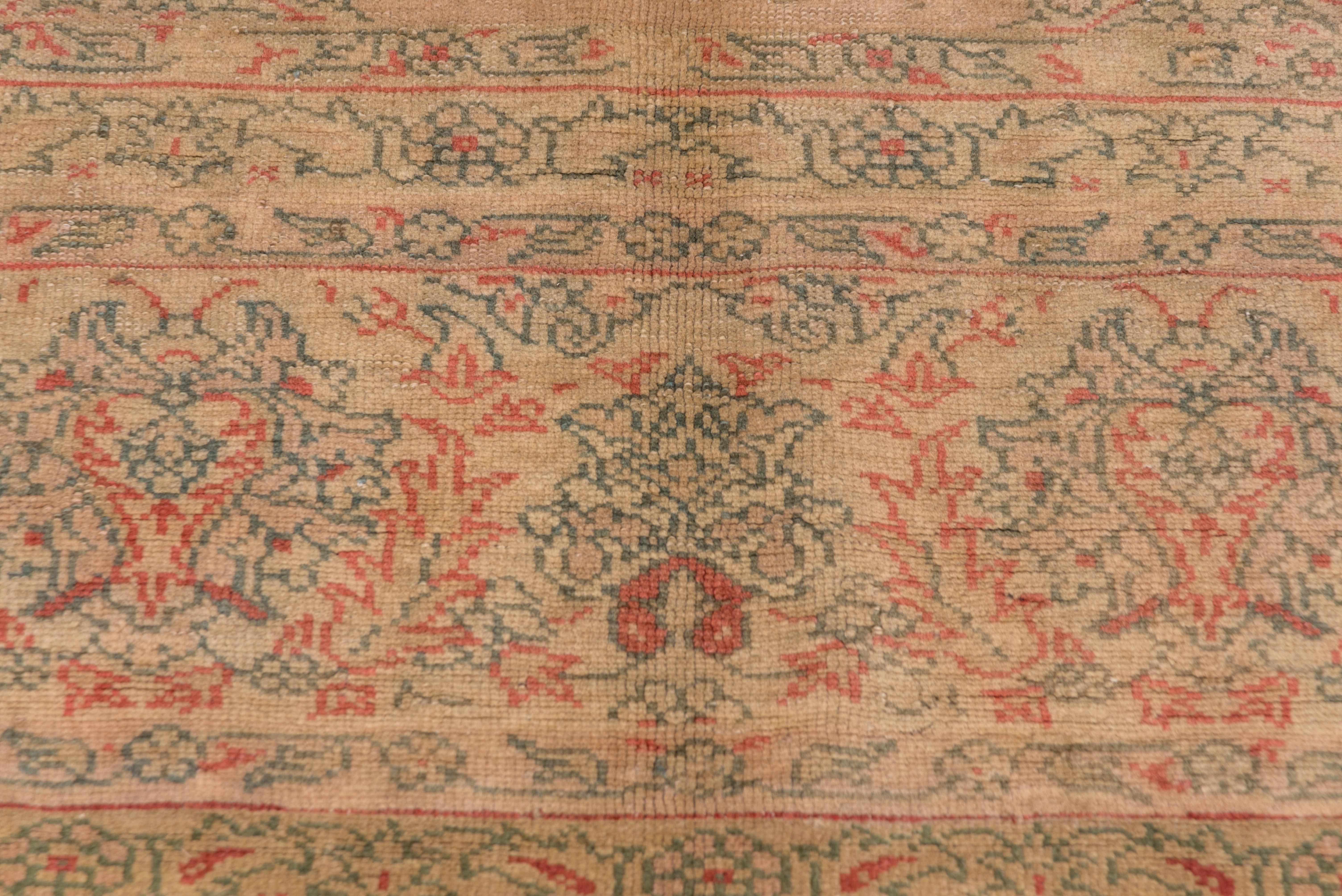 The warm beige field shows a floating doubly pendanted filigree 16-point medallion enclosing palmettes. En suite extended corners. Border with well-drawn reversing palmettes. Fairly good condition with general light wear. Green and light red accents.
