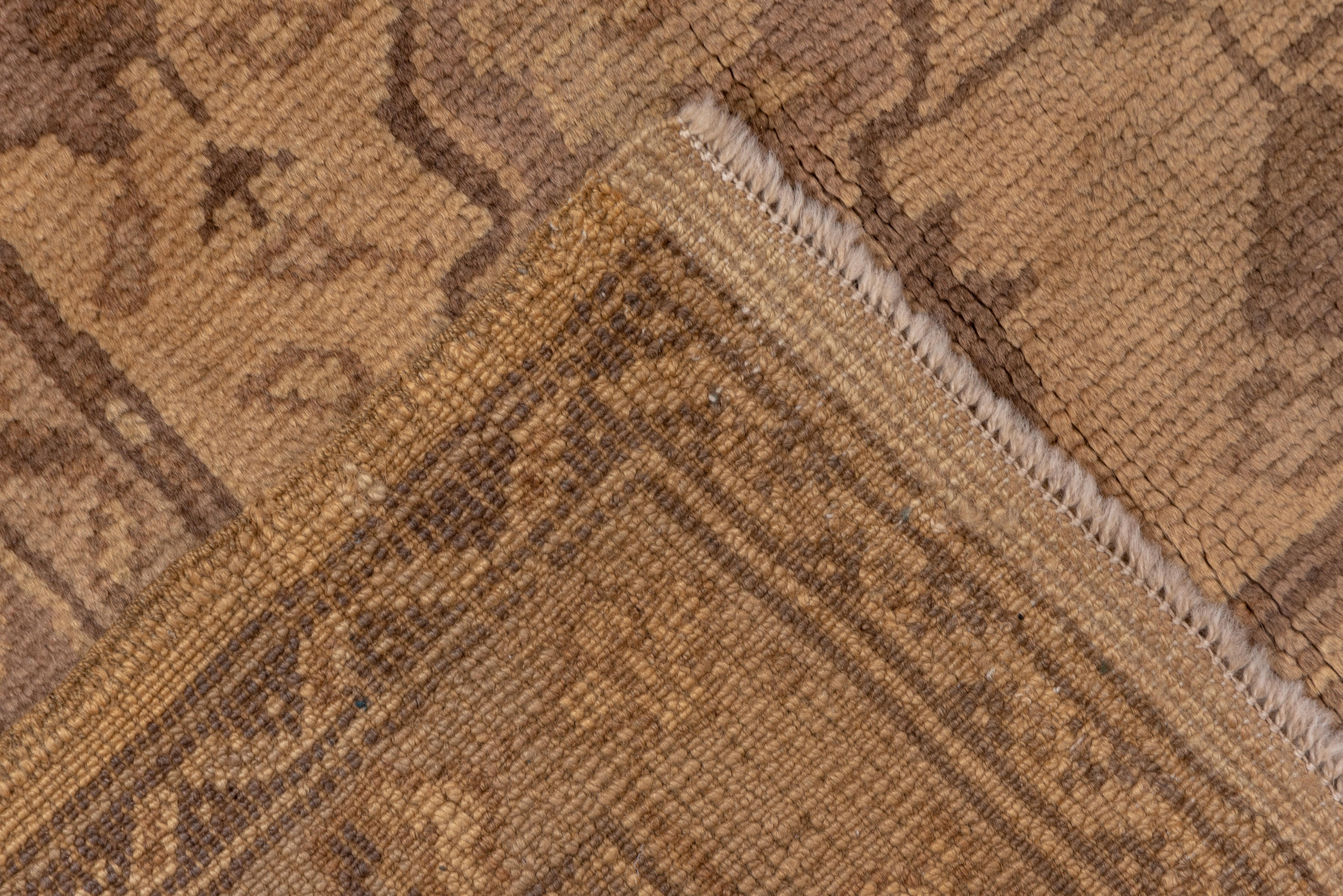 In a semi-geometric style with short fluted lateral columns joining the lobed corner pieces, defining a straw-buff field anchored by a pendanted stepped and lobed pale lavender medallion. Stiff floral sprays around. Ragged and petal palmettes on a