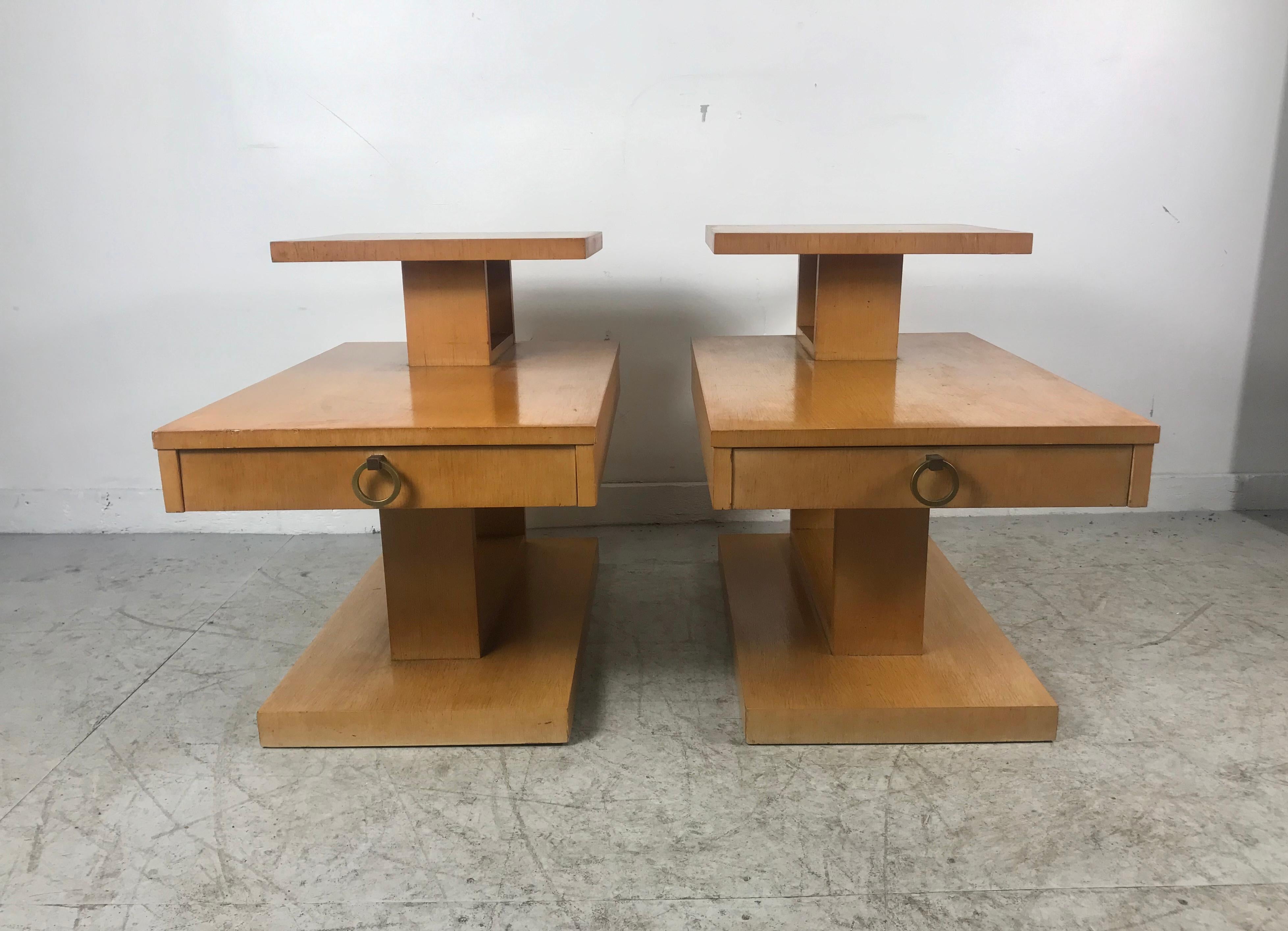 Pair of Classic Mid-Century Modern step end tables with drawers by Lane. Blond mahogany retains they're original finish in usable condition, minor water spot to tops, would be fabulous refinished, lacquered. Stunning brass ring hand pulls.