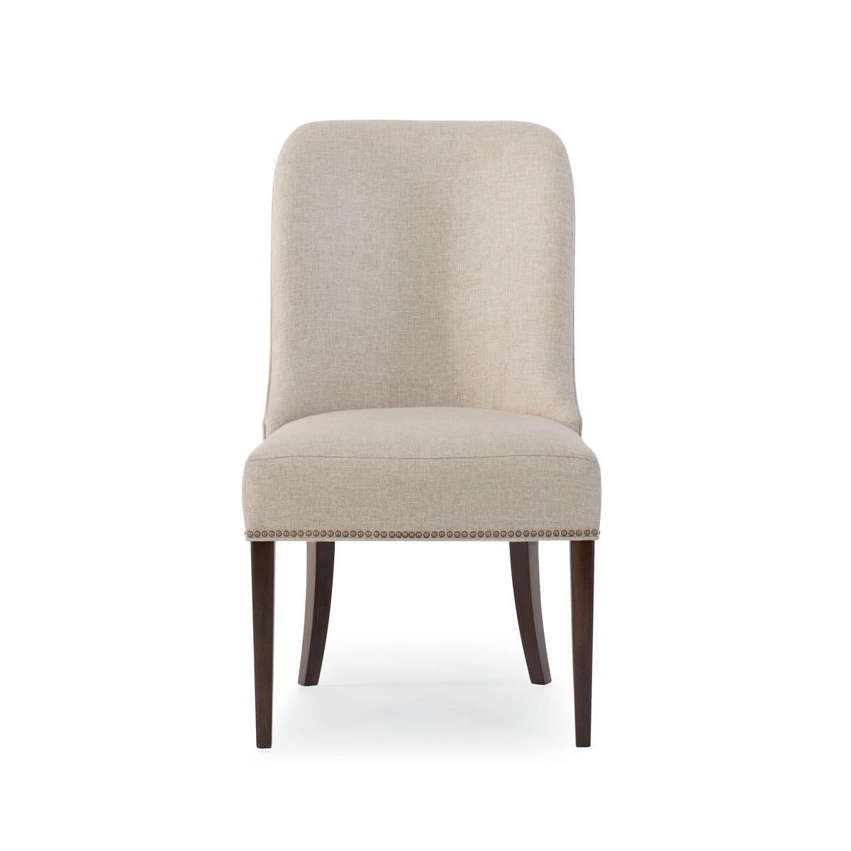 Clean, classic lines, fully upholstered in a neutral brushed fabric, with tapered sabre legs are finished in Bourbon Glaze. With its band of brass nails at the base, these chairs pair well with modern and transitional pieces.

Dimensions: 23