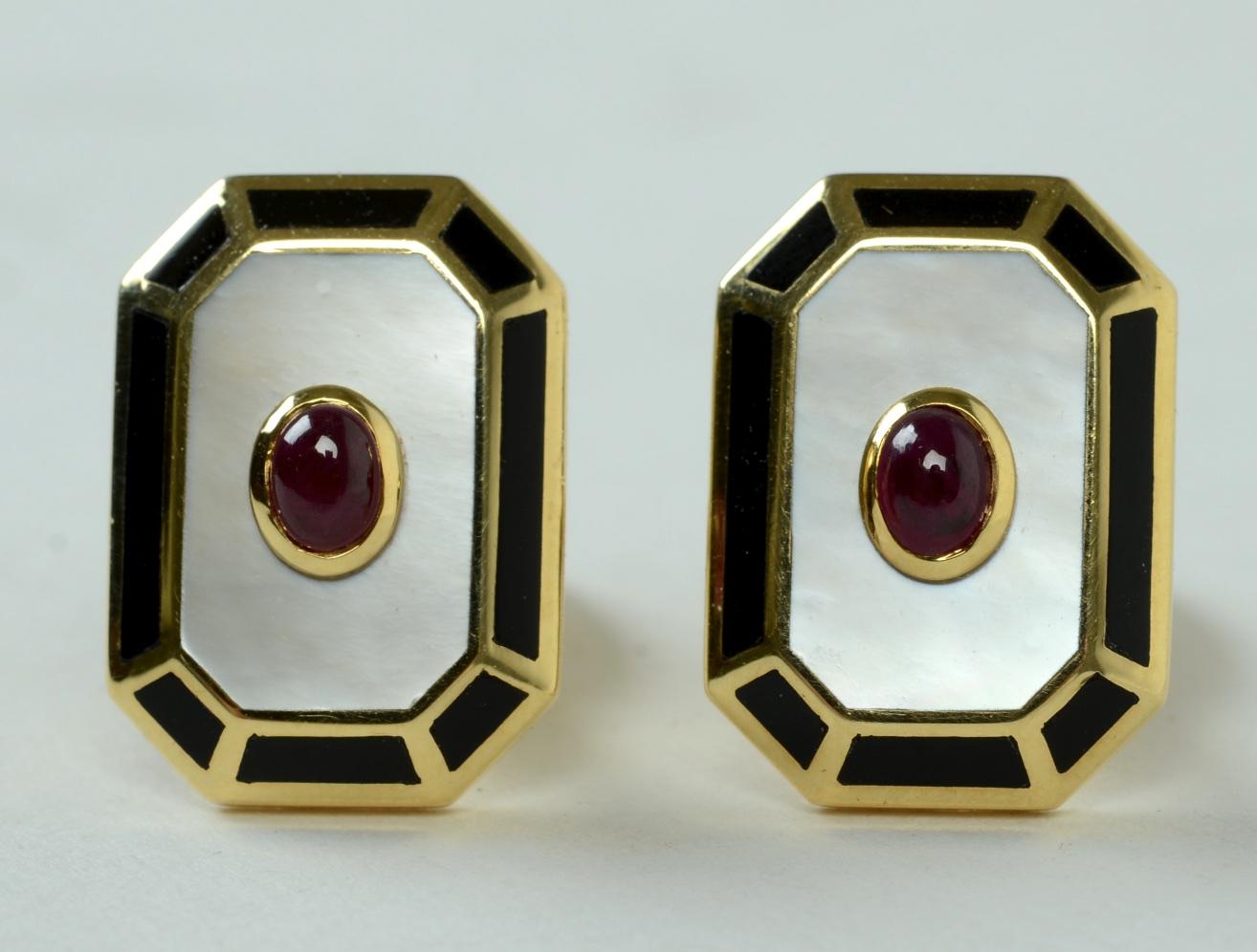 Pair of Art Deco Style, Mother of Pearl, Cabochon Ruby, and Black Onyx Cufflinks set in 18KT yellow gold, by Rosa Cellini Gioielli. The oval, bezel set cabochon ruby is centered on a mother of pearl convex polygon. The sides have 18KT yellow gold