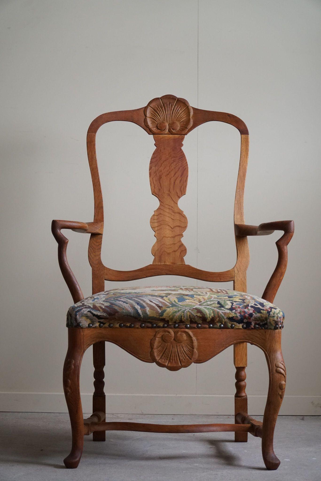This finely handcrafted armchair, made by a Danish cabinetmaker in the 1930s, exemplifies the grandeur of the Baroque style. Constructed from solid oak, the chair features intricate carvings and ornate details, showcasing exceptional craftsmanship.