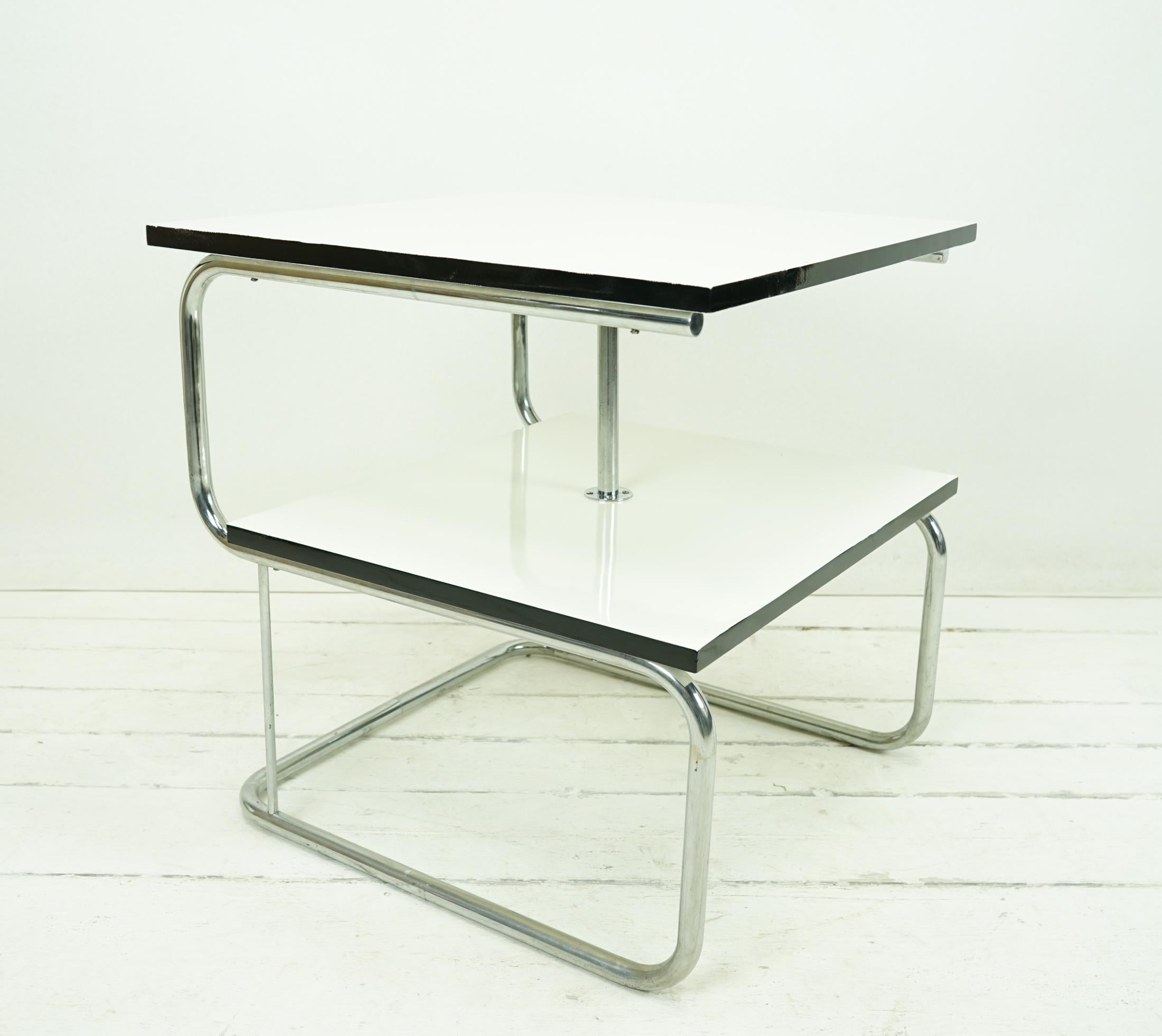 Object: Table

Time: original around 1935
 
Design/Manufacturer: Mücke Melder

Dimensions: H 73,5 W 70 D 70

Table with two lacquered square blockboards
Pearl white with black edges
Chrome frame

10 (impeccable condition)
9 X patina,