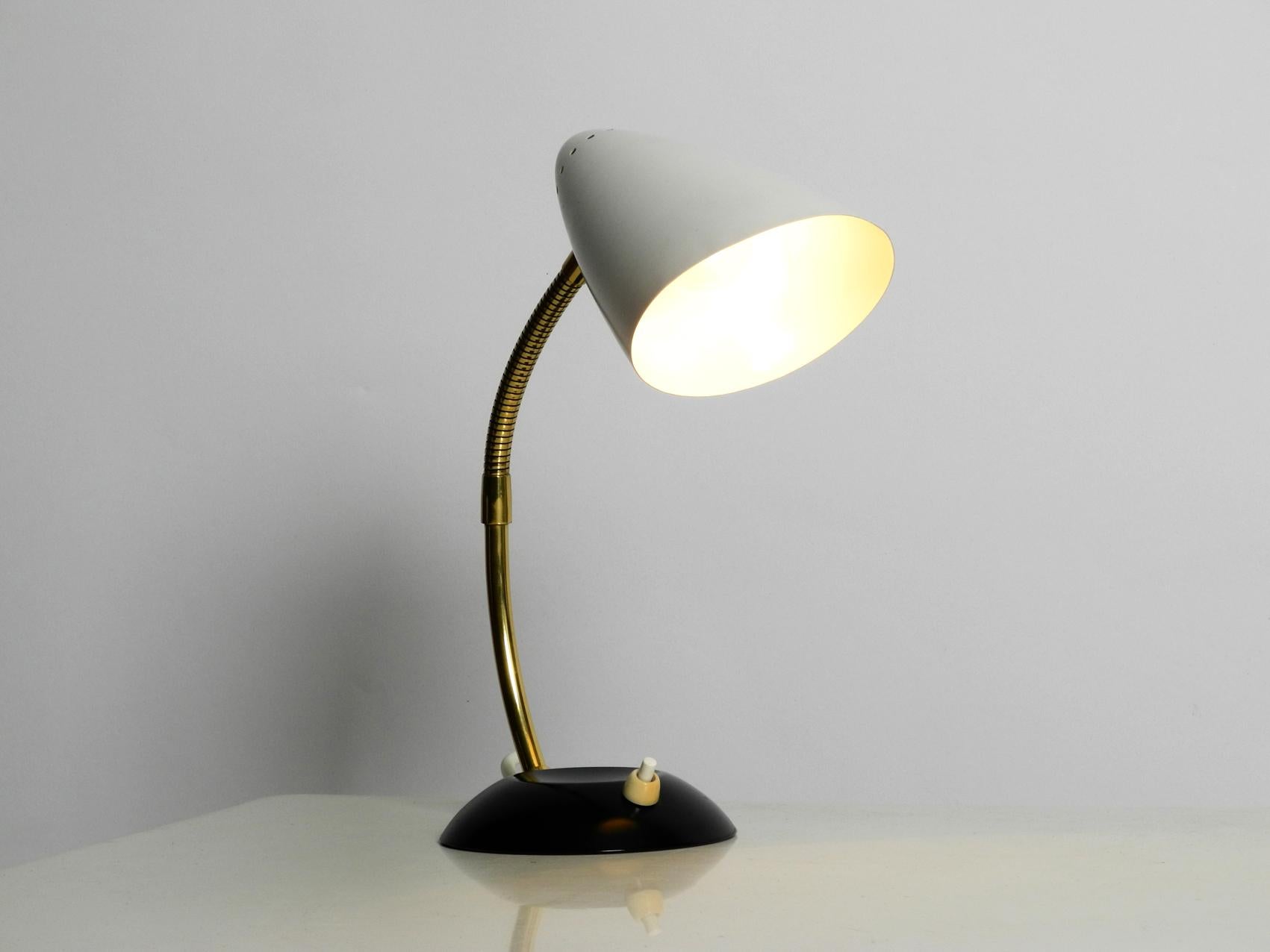 Very beautiful Classic Mid-Century Modern table lamp by Kaiser Leuchten. 
Very nice striking Minimalist and typical midcentury design with a fantastic patina. 
Shade and base are made of metal, painted in black and white. The neck is made of
