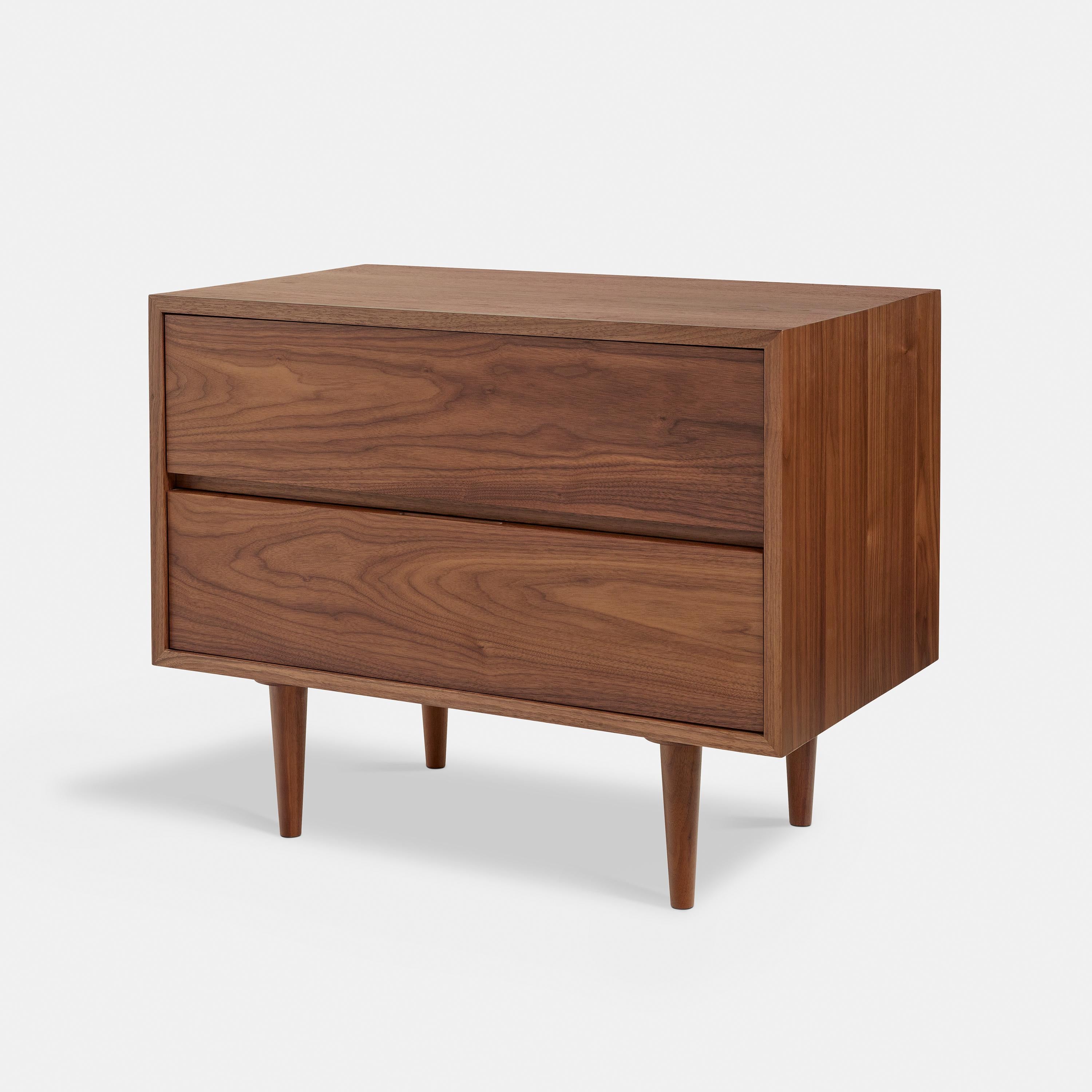 Exuding mid-century appeal through its simple elegance, the Bedside Table is a welcome addition to the Smilow Bedroom Collection. The table features two drawers and is built entirely from solid wood. Additionally, the table is wide enough to