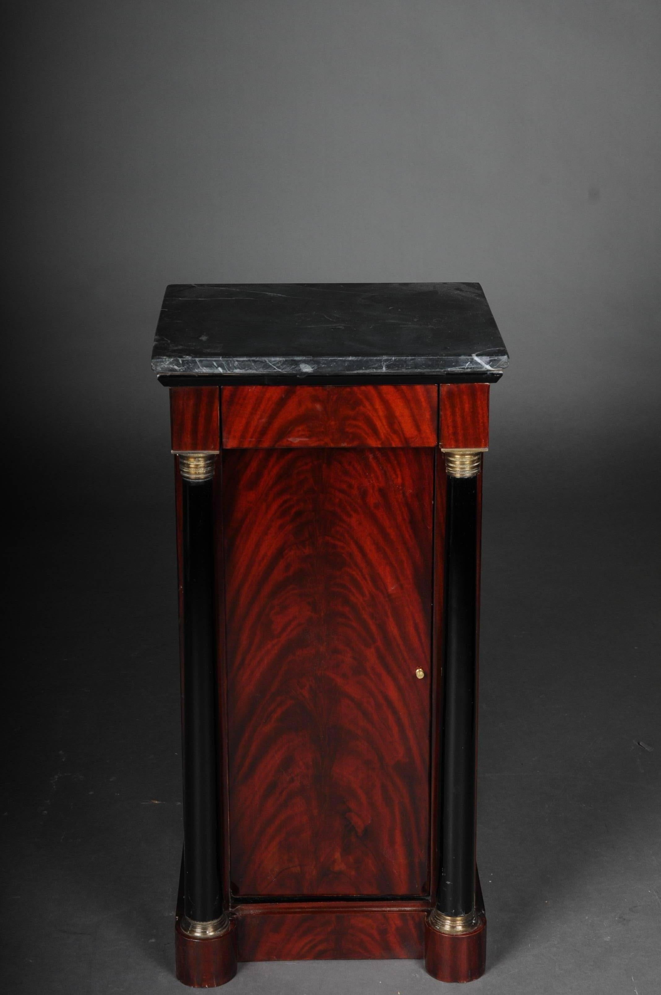 Classic bedside table, side table in Biedermeier, mahogany, left
Mahogany veneer on solid wood. High rectangular left-opening body on scalloped pedestal. Single-door in the front, flanked on the sides by full columns with brass bases and capitals,