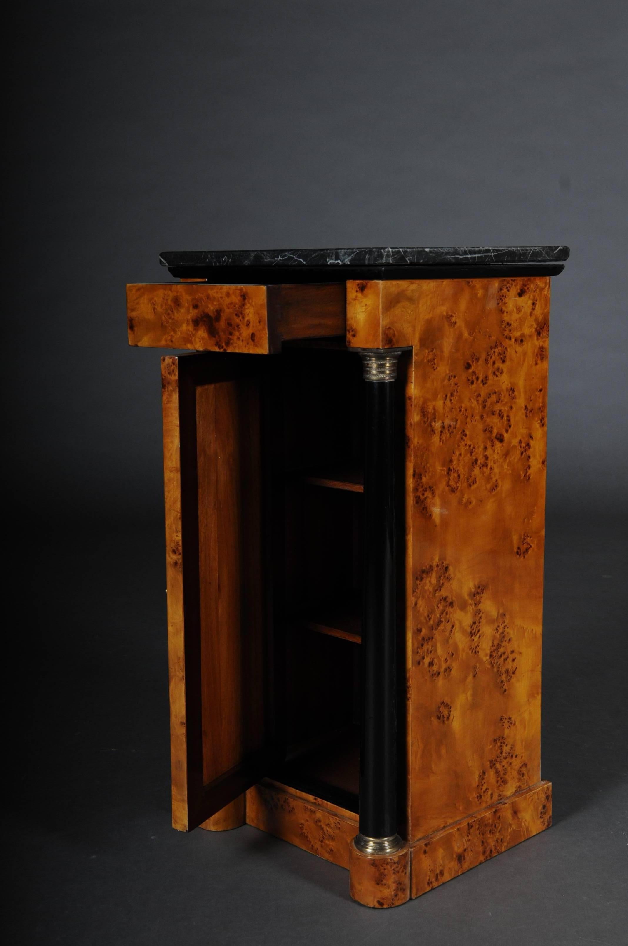 Classic bedside table, side table in Biedermeier style, maple root L
Maple root veneer on solid wood. High rectangular left-opening body on scalloped pedestal. Single-door in the front, flanked on the sides by full columns with brass bases and