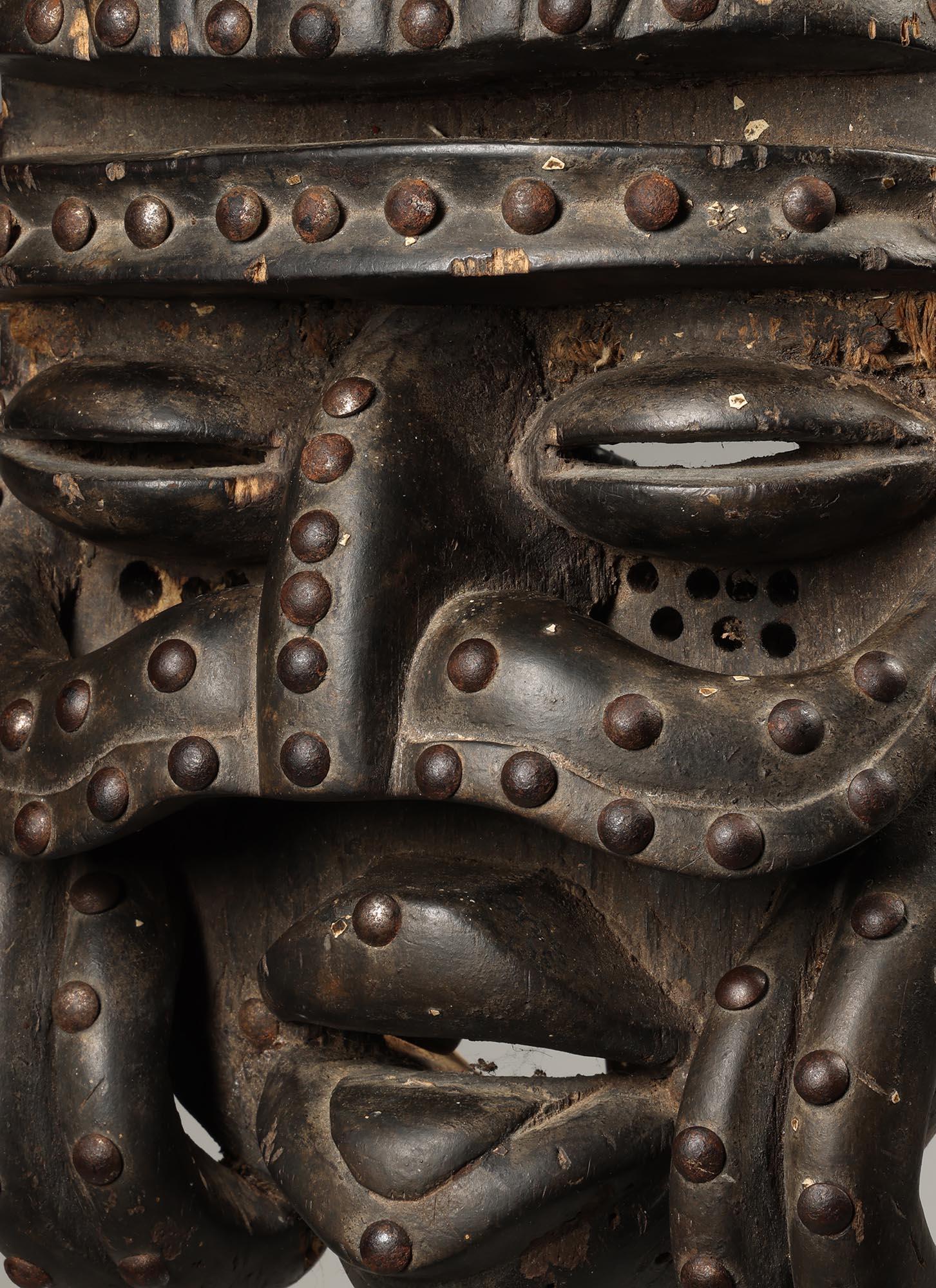 Bois Masque de bété classique avec défenses incurvées à moustaches et clous, Côte d'Ivoire, Afrique en vente