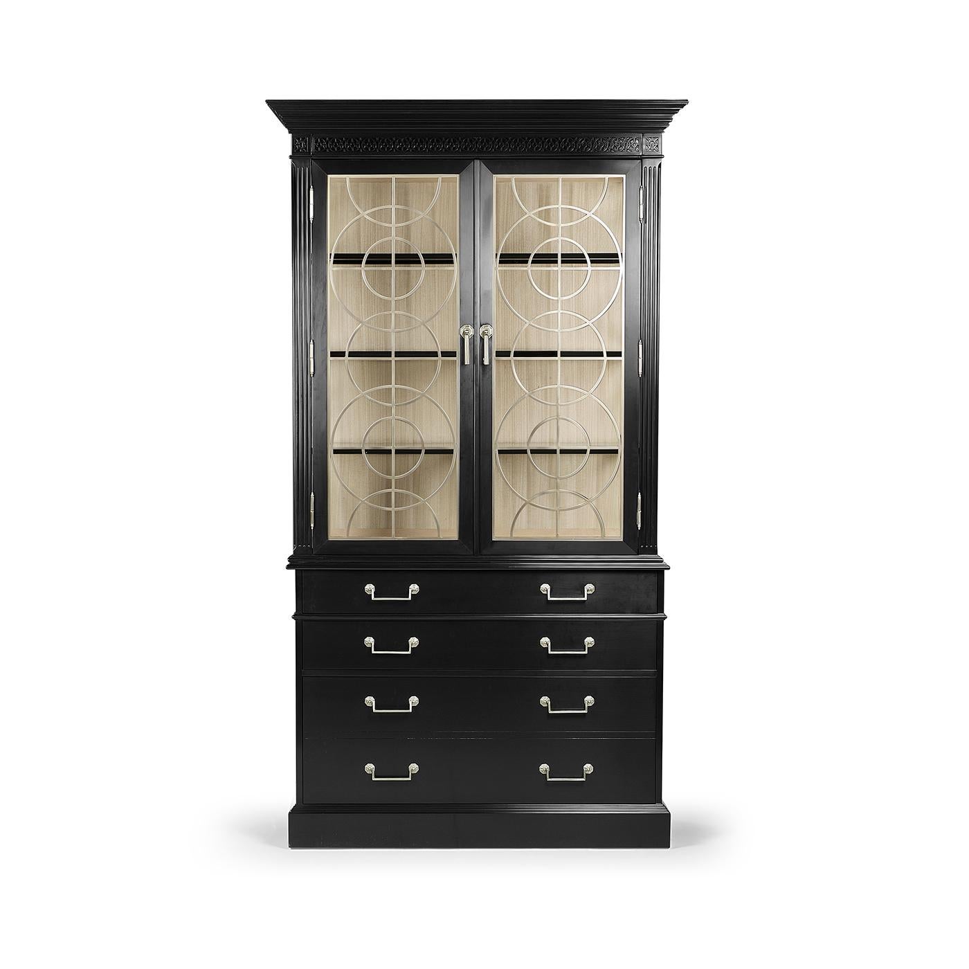 Realizzato in legno pregiato con una formale finitura nera, presenta suggestivi accenti geometrici in metallo sulle ante in vetro, per mettere in mostra con eleganza gli oggetti da collezione. Le impiallacciature in Koto biondo rivestono gli