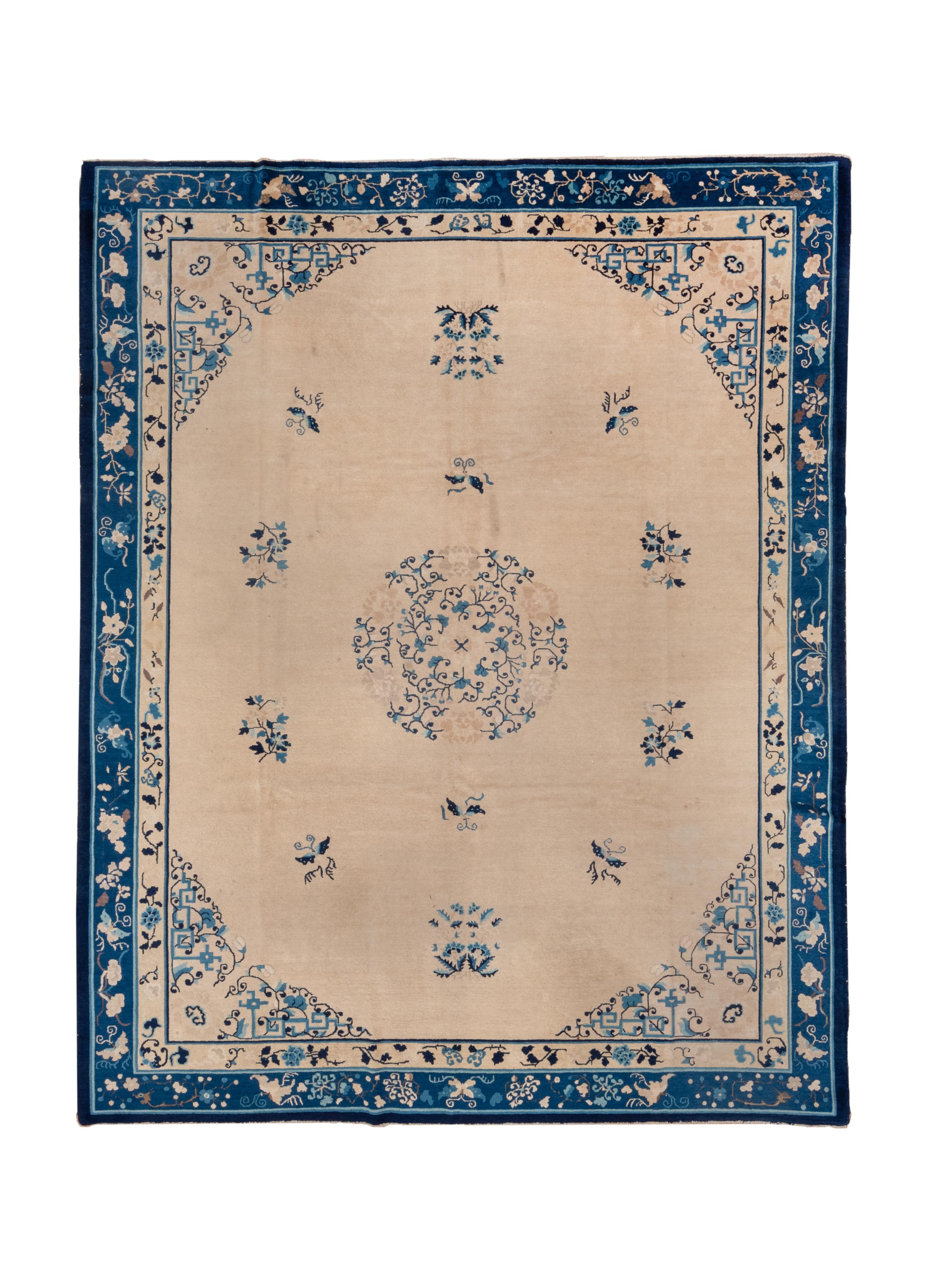 This classic blue-and-white carpet shows a rounded cream field with butterflies and floral sprays discreetly surrounding an openwork wreath and inner circular floral medallion.  Delicate arabesque corners. Narrow dark blue main border with