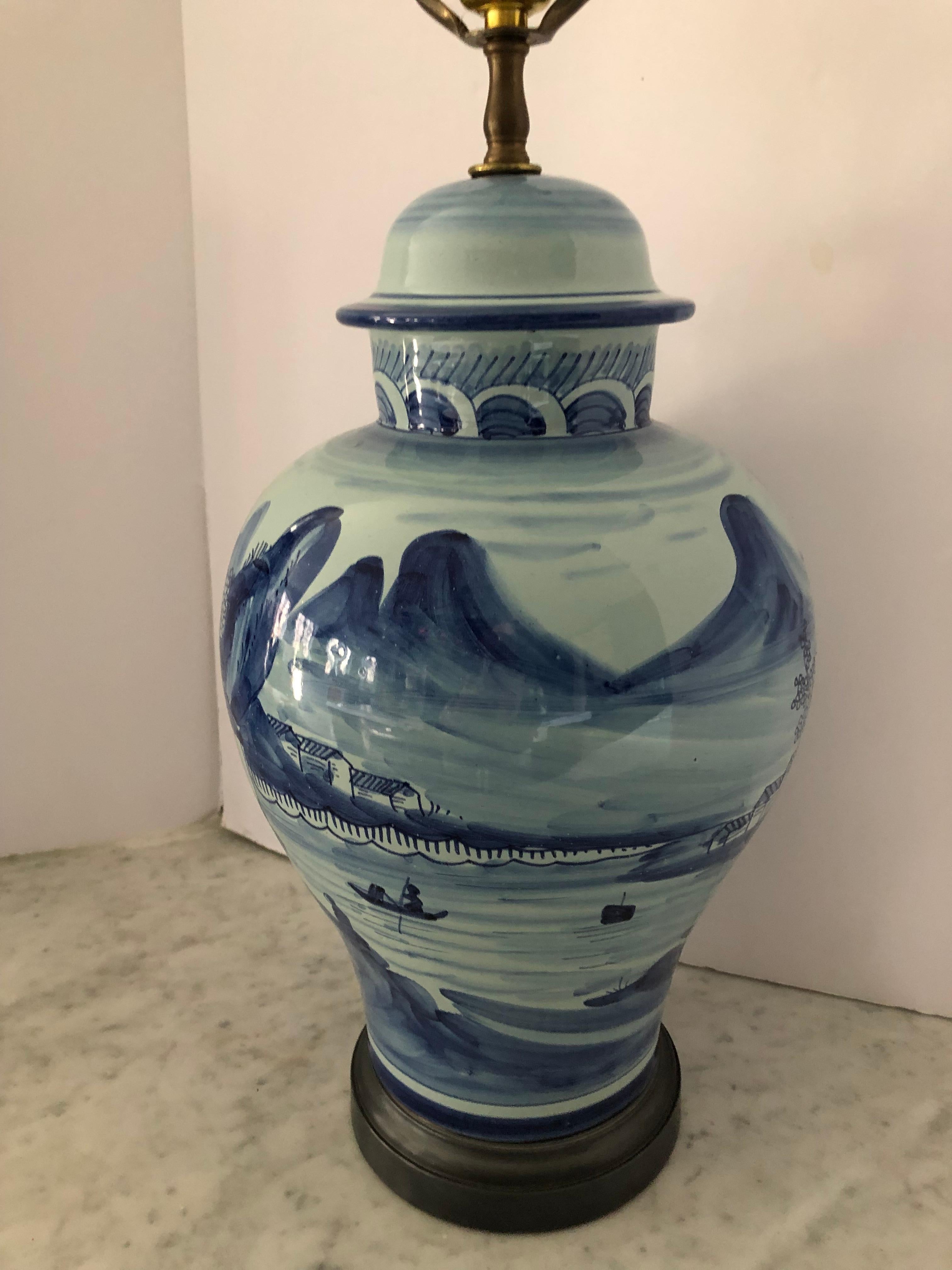 Classic blue and white ginger jar table lamp by Chapman. Lamp depicts Asian scenery and has a black base. Finial is a matte black ball. Chapman label.
 