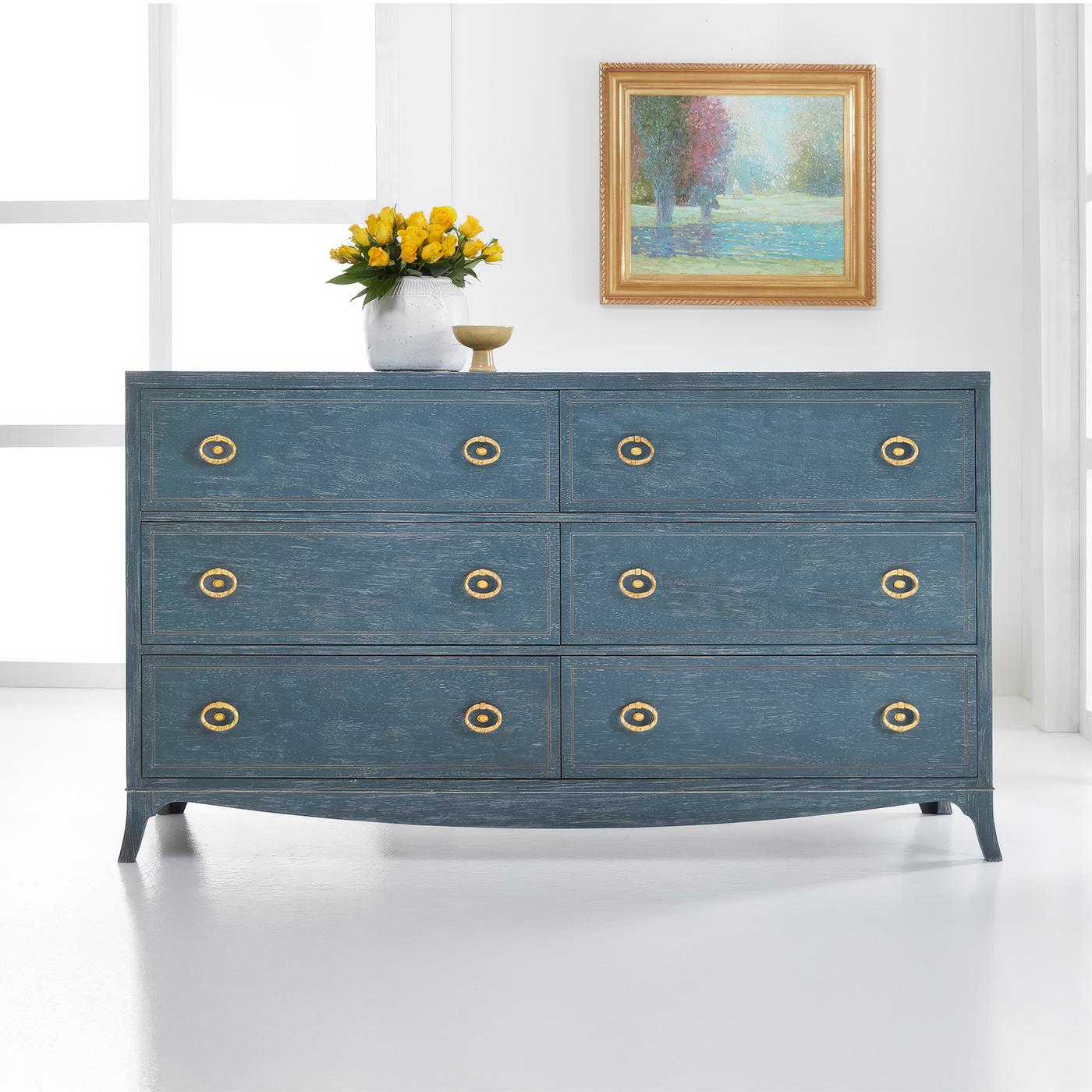 Dresser embodies timeless elegance with its refined proportions and thoughtful details. The distressed blue painted finish creates an elegant, clean canvas that highlights its architectural elements, while a painted line inlay and decorative brass