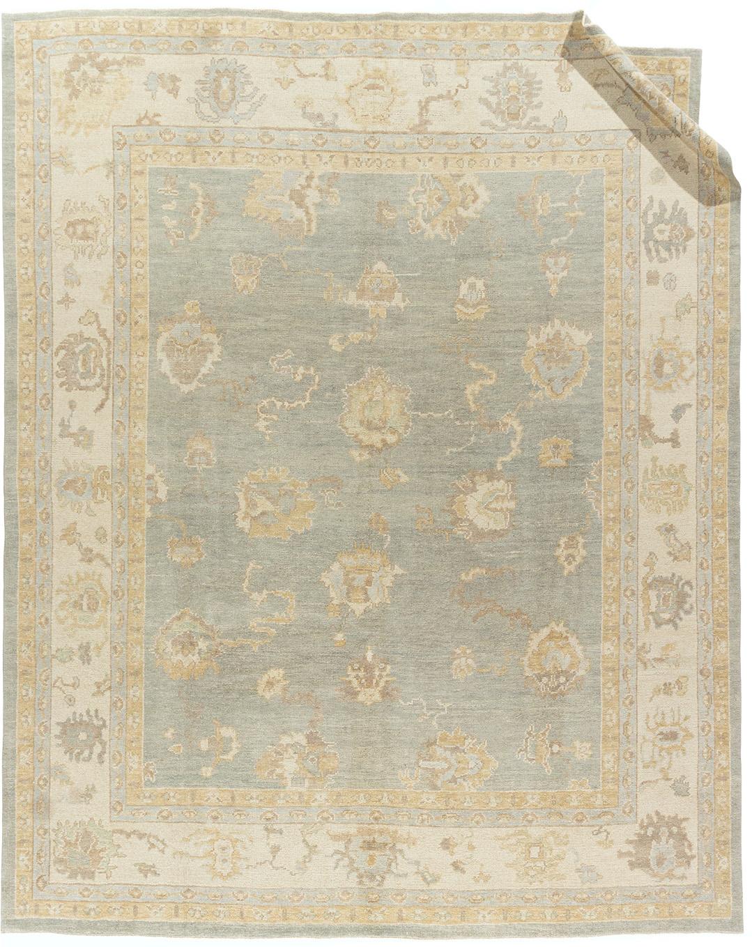 9' x 11'. Une recréation magistrale d'un tapis Oushak classique, tissé à la main en Inde par des artisans qualifiés utilisant les matériaux les plus fins. Cette pièce capture l'élégance intemporelle du design Oushak traditionnel, avec des tons doux