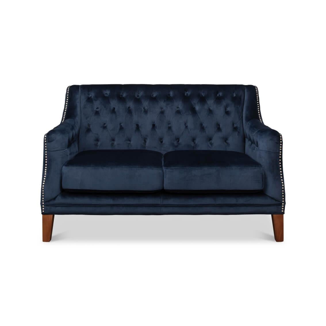 Dieses mit prächtigem marineblauem Samt bezogene Sofa verfügt über eine klassische, tiefe Knopfheftung, die ein raffiniertes Rautenmuster erzeugt.

Die anmutigen Kurven seiner Silhouette werden durch eine geschmackvolle Nagelkopfverzierung
