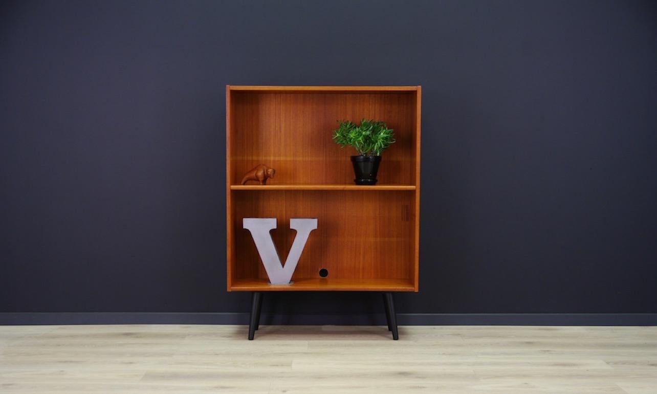 Classic bookcase from the 1960s-1970s, minimalistic form, Danish design. Teak veneered surface, adjustable shelves. Preserved in good condition (minor scratches, filled veneer loss, cable hole), directly for use.

Dimensions: height 116 cm, width