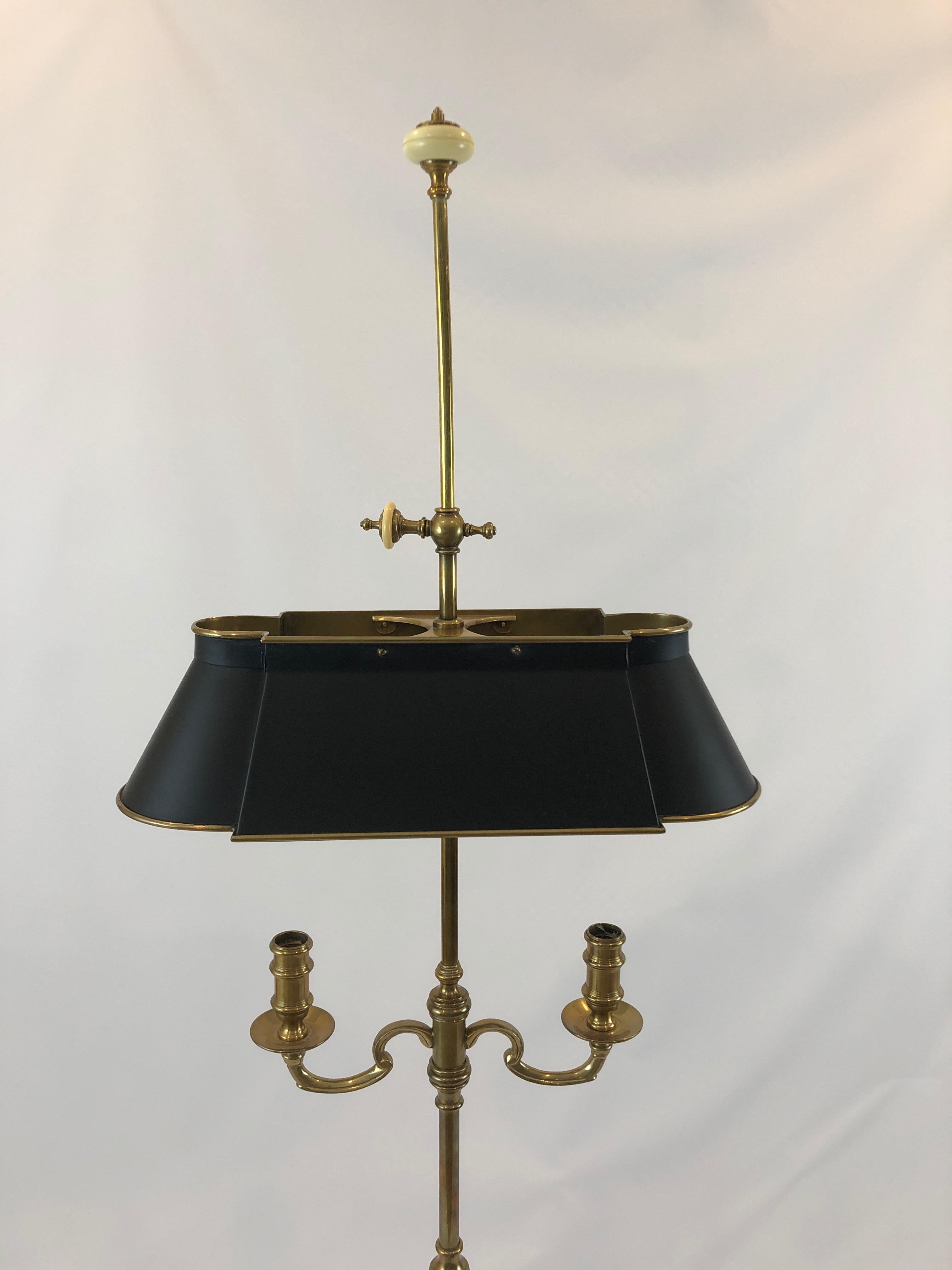 Handsome Chapman brass floor lamp in a versatile elegant medium size having 2 arm candlestick design, black and gold metal shade and sockets for two bulbs. Cream enamel finials are a nice touch.