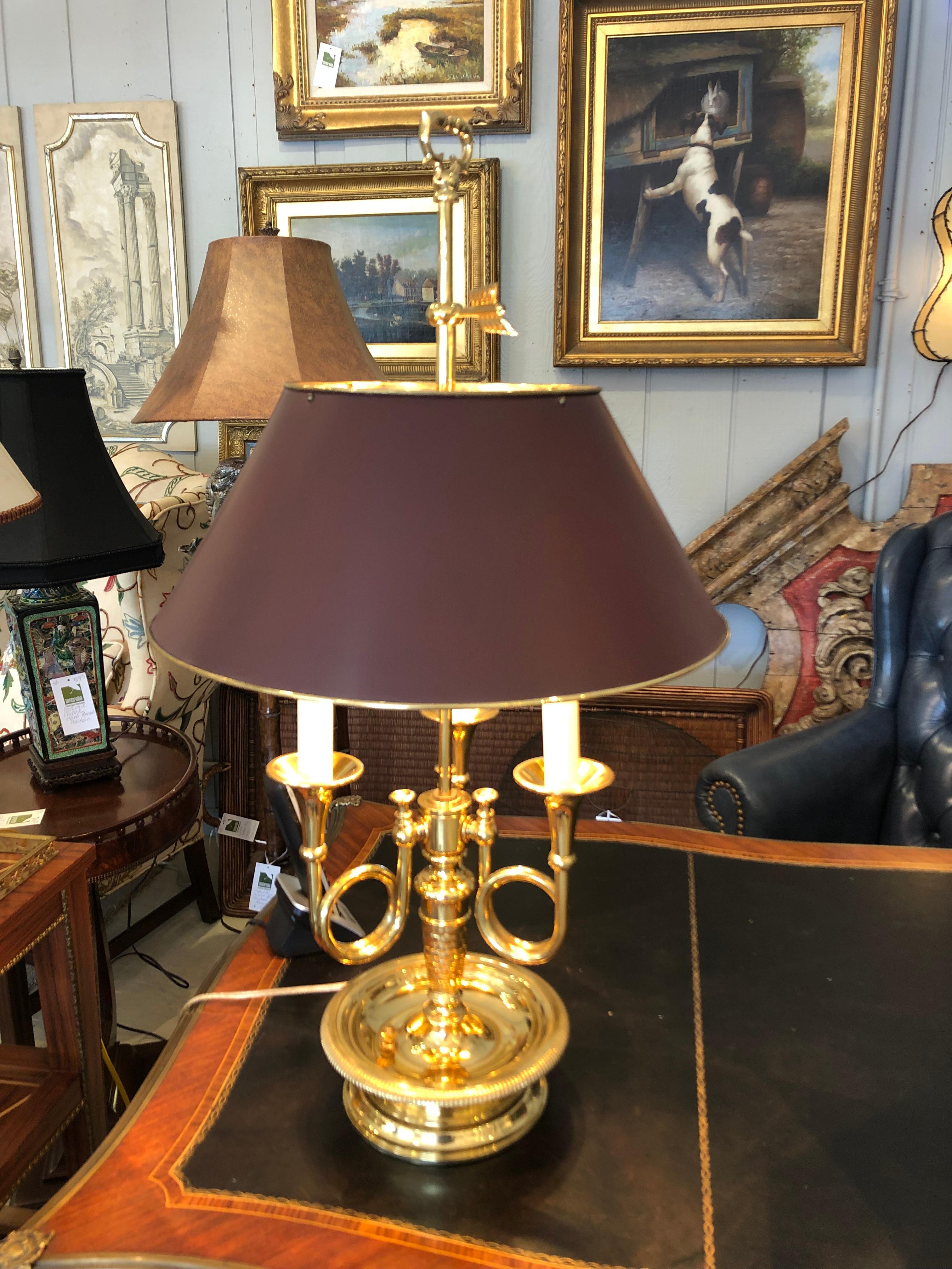Classically handsome adjustable buillotte table lamp having 3 French horns as the arms, beautiful detailing on the brass, and yummy dark browish burgundy maroon metal shade lined in brass.
Base is 7.5 diameter.