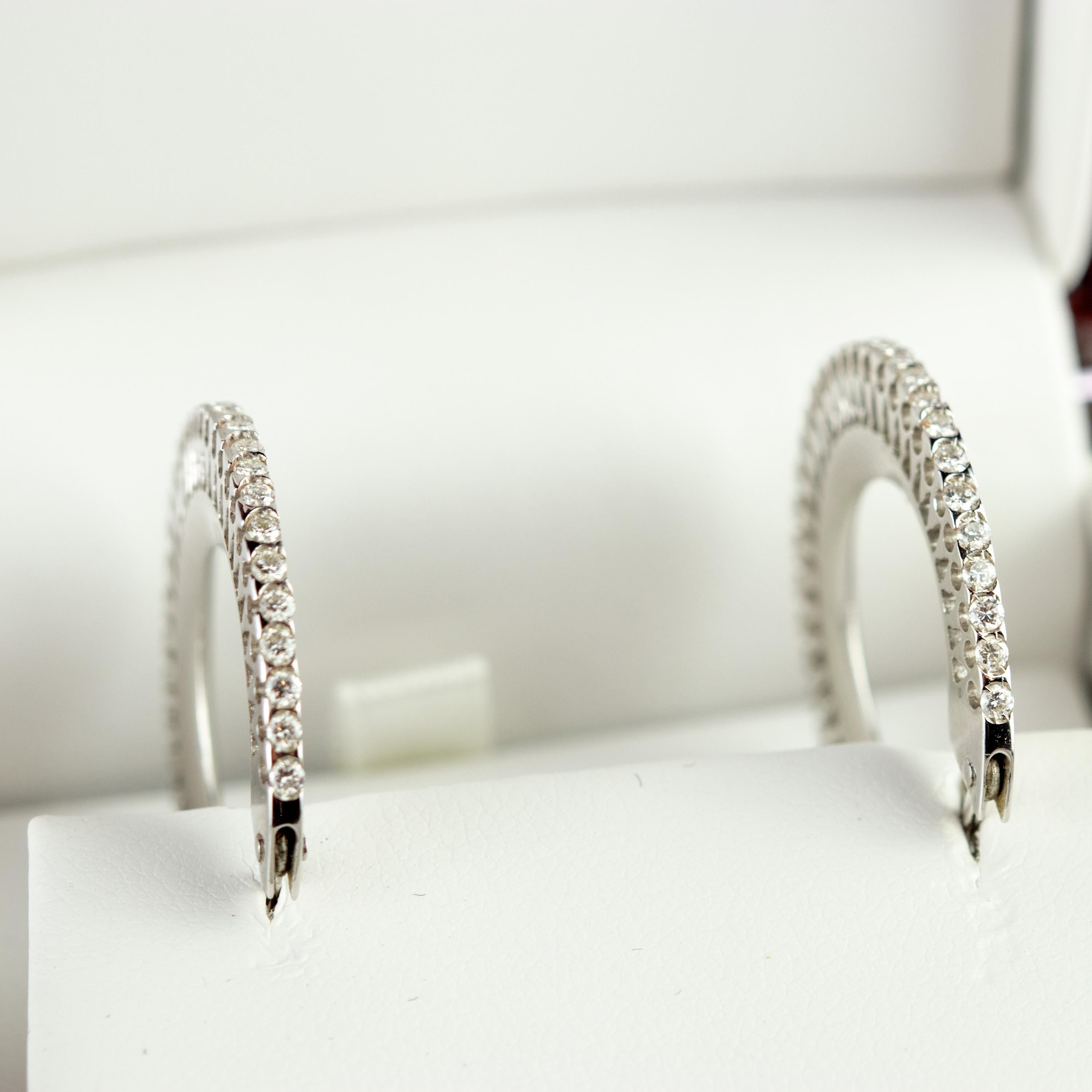 Enjoy the absolute beauty of this resplendent, classic and perfect pair of diamond hoops! These medium inside out diamond hoop earrings in 18 karat white gold brilliant diamond line. With 0.9 carat, these handmade precious gems will shine on any