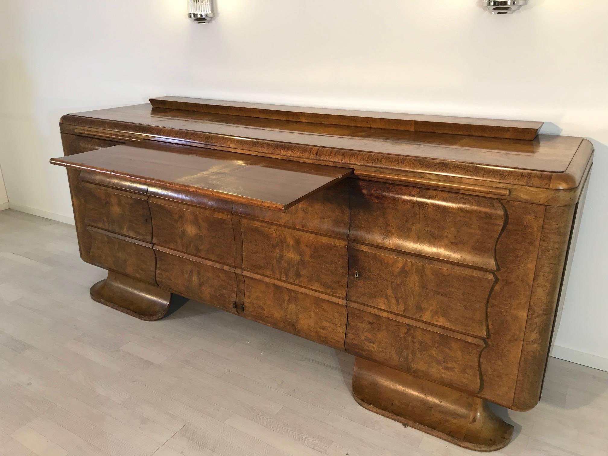 Large Art Deco sideboard with great burl wood veneer made of walnut wood. This unique single piece convinces with its beautiful Art Deco body, great French feet and fine details. A real eyecatcher in every living room with a wonderful combination of